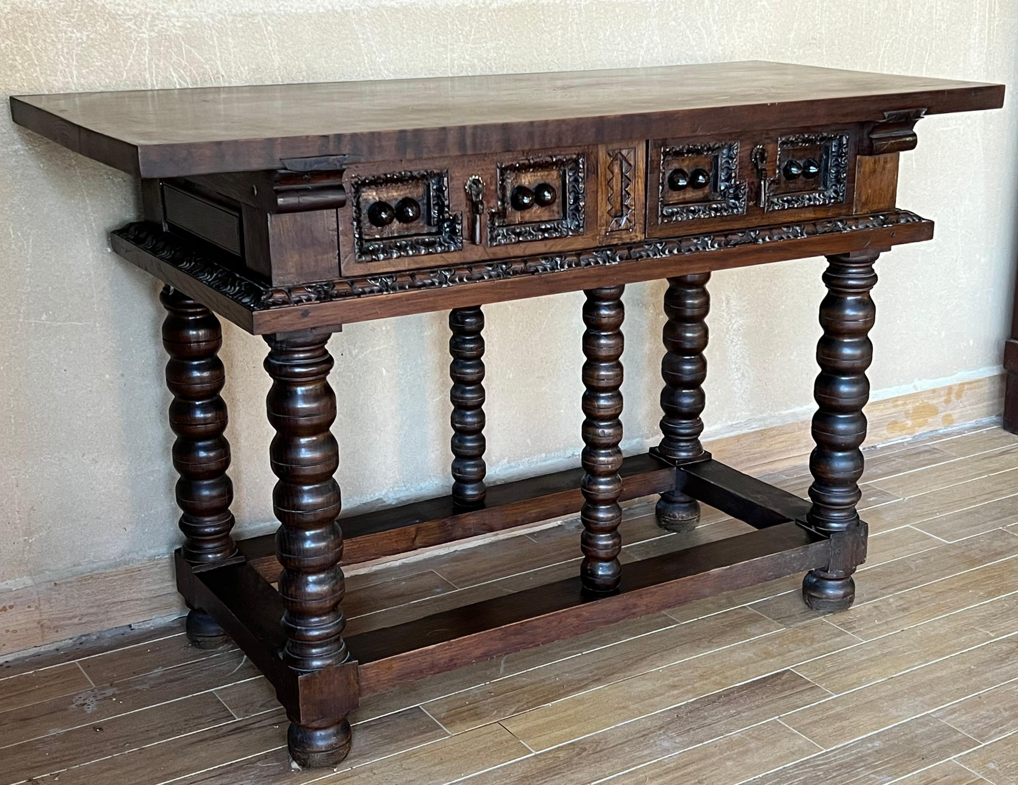 This large Spanish late 19th century features a beautiful one plank rectangular top over two richly carved drawers. Each drawer, featuring slightly different hardware, is adorned with floral motifs. Rosettes are carved around the drawers and each