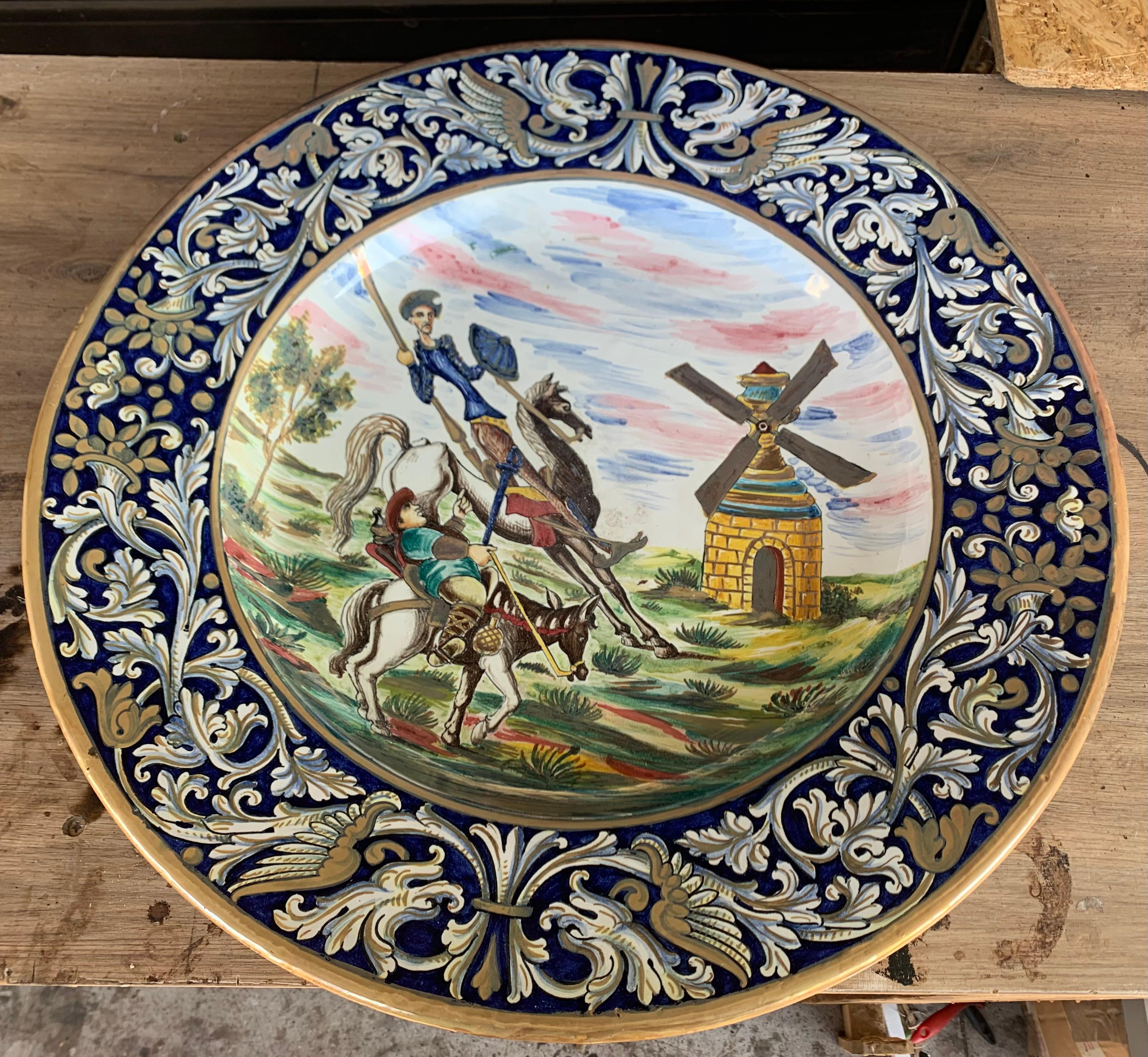This beautiful plate features Don Quixote, the most popular character in Spain from the Spanish literature.
The dish has iridiscents details and a foliate decoration in the edge. The main picture features a typical scene of this book.