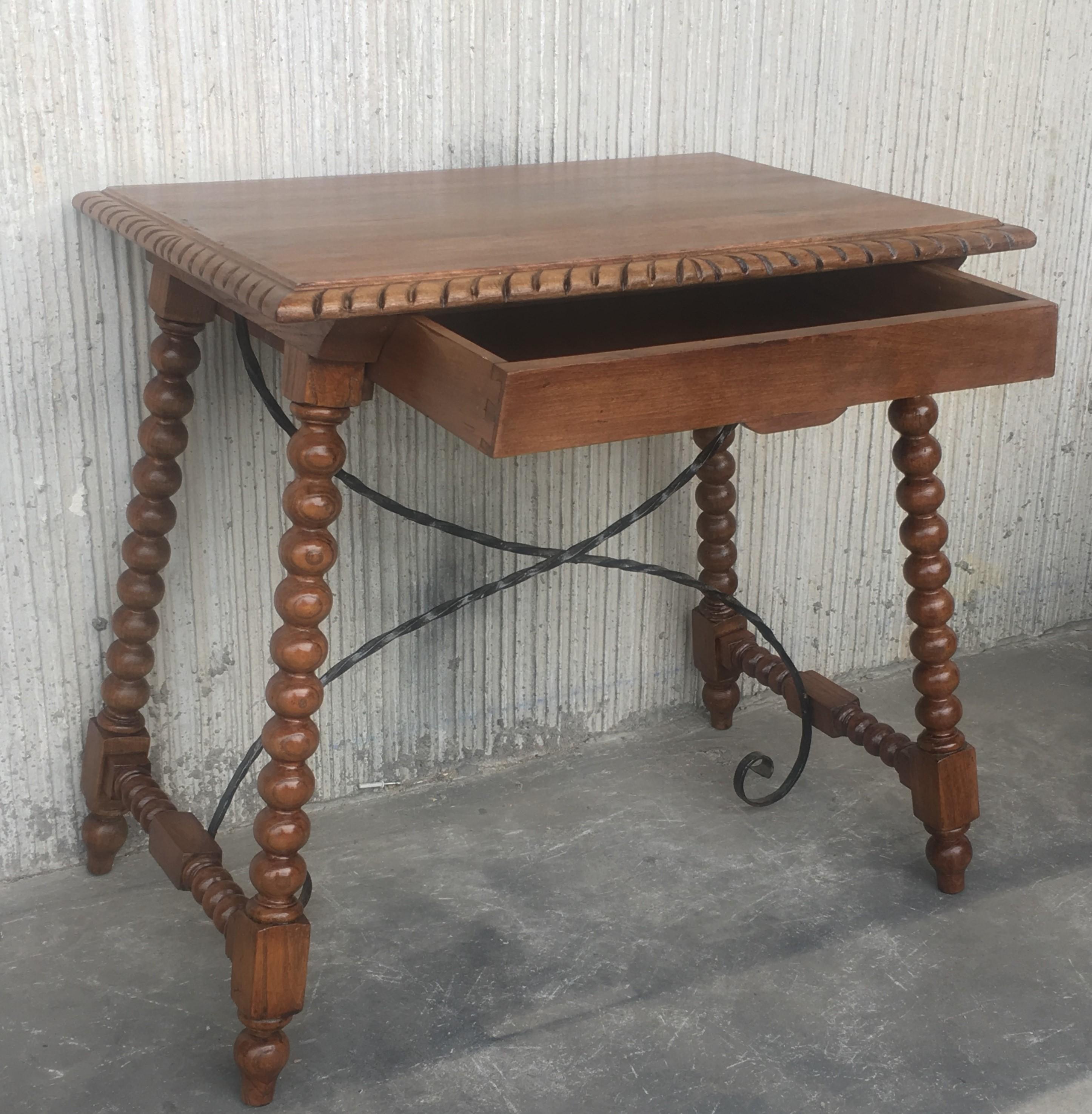 19th century Spanish farm table with iron stretchers, hand carved top and drawer.

An unusual form with nice shiny patina. Nice size for a side or end table, or as a lamp table. Graceful carved supports with a shaped edge on the top. The single