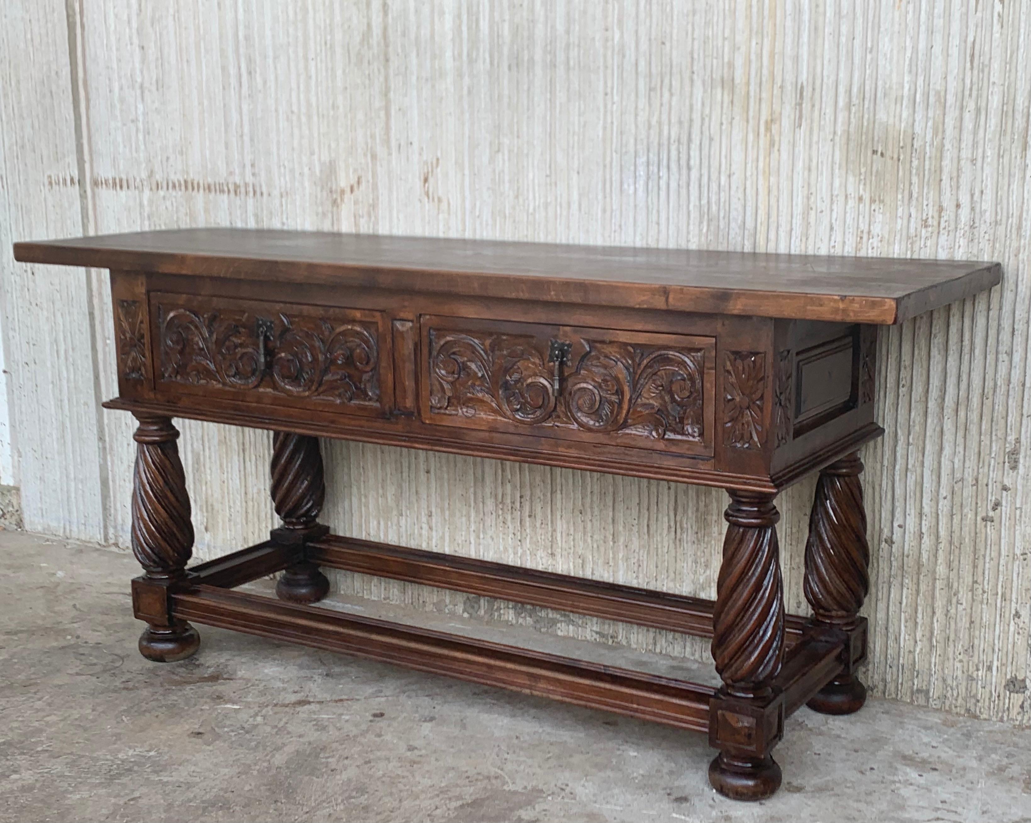 This large Spanish late 19th century features a beautiful one plank rectangular top over two carved drawers. Each drawer, featuring slightly different hardware, is adorned with geometrical motifs. Rosettes are carved between the drawers and each