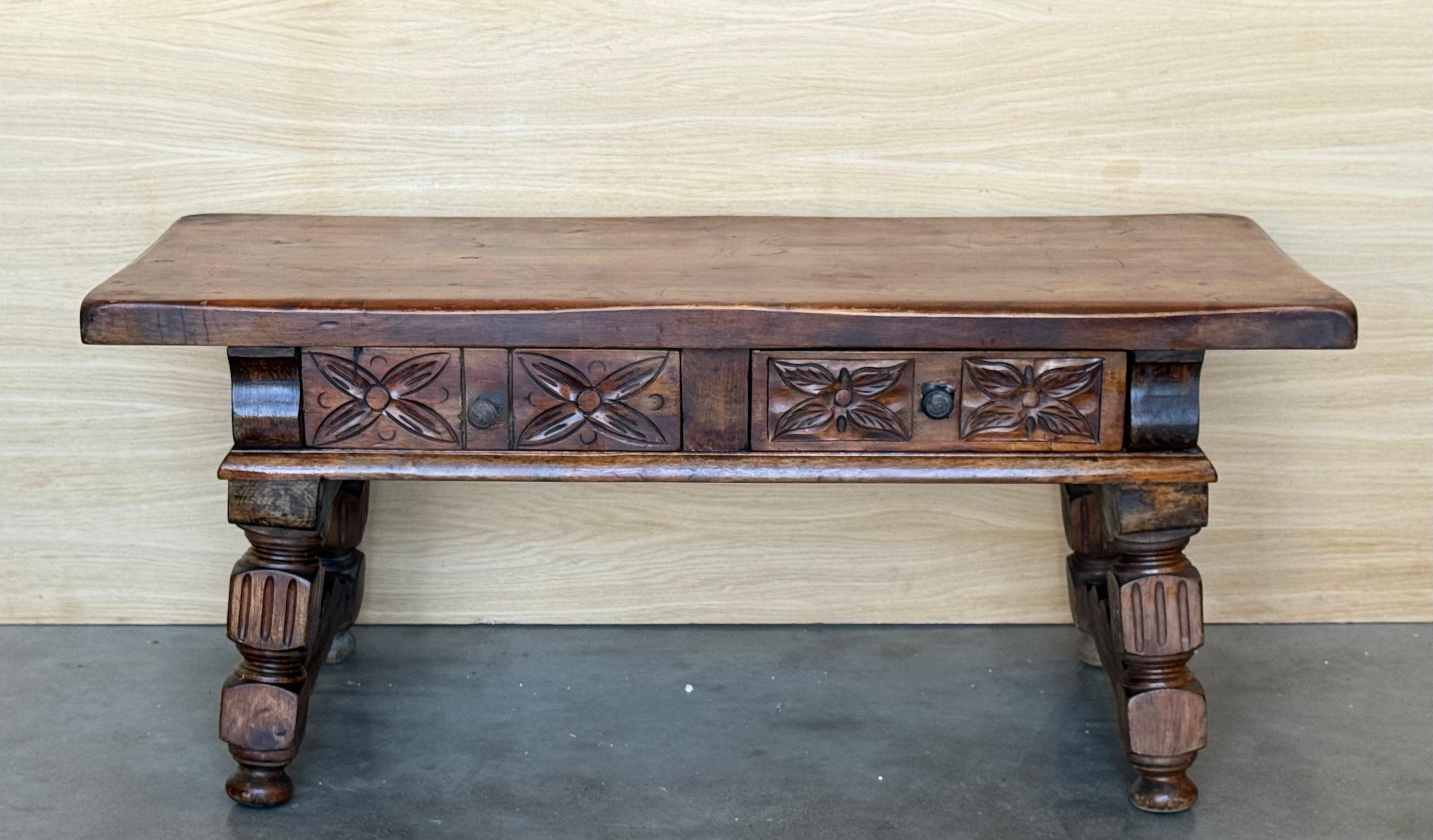 This lox  Spanish table late 19th century,  features a beautiful one plank rectangular top over two carved drawers. Each drawer, featuring slightly different hardware, is adorned with geometrical motifs. Rosettes are carved between the drawers and