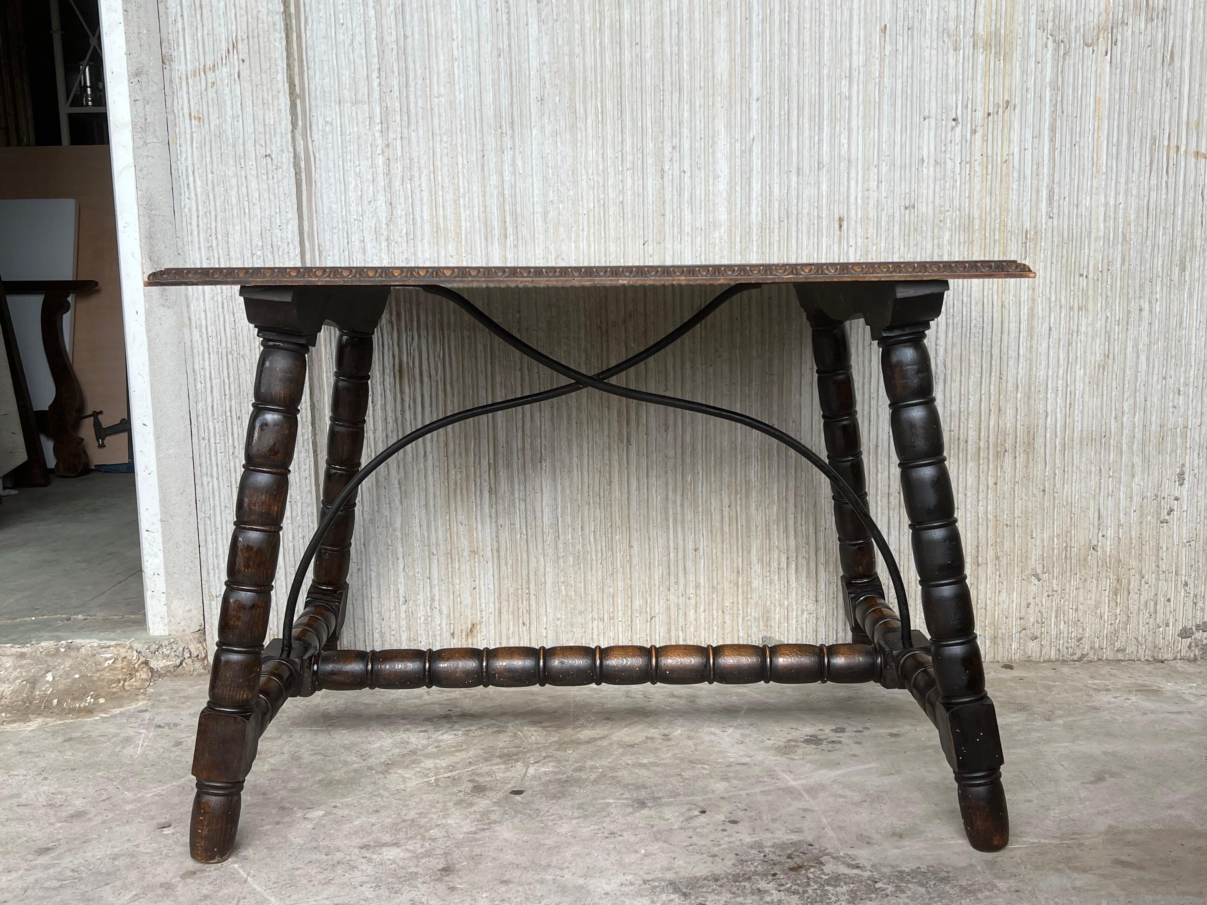 Tavolino spagnolo del XIX secolo con gambe tornite e barella in legno e barella in ferro 
Il piano presenta bordi intagliati e una bellissima venatura e patina.
