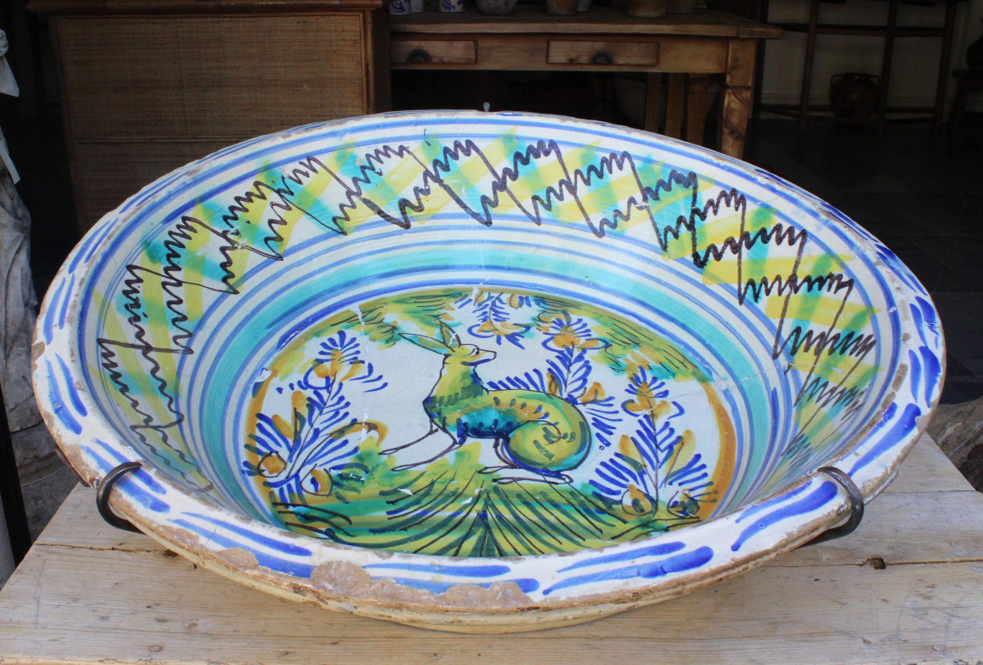 19th century Spanish Triana white, green, blue and yellow glazed terracotta plate.

Triana is a style that originates in Seville, known for its mix of Christian and Al-Andalus cultures.

With escenes of a town and trees in the middle and geometric