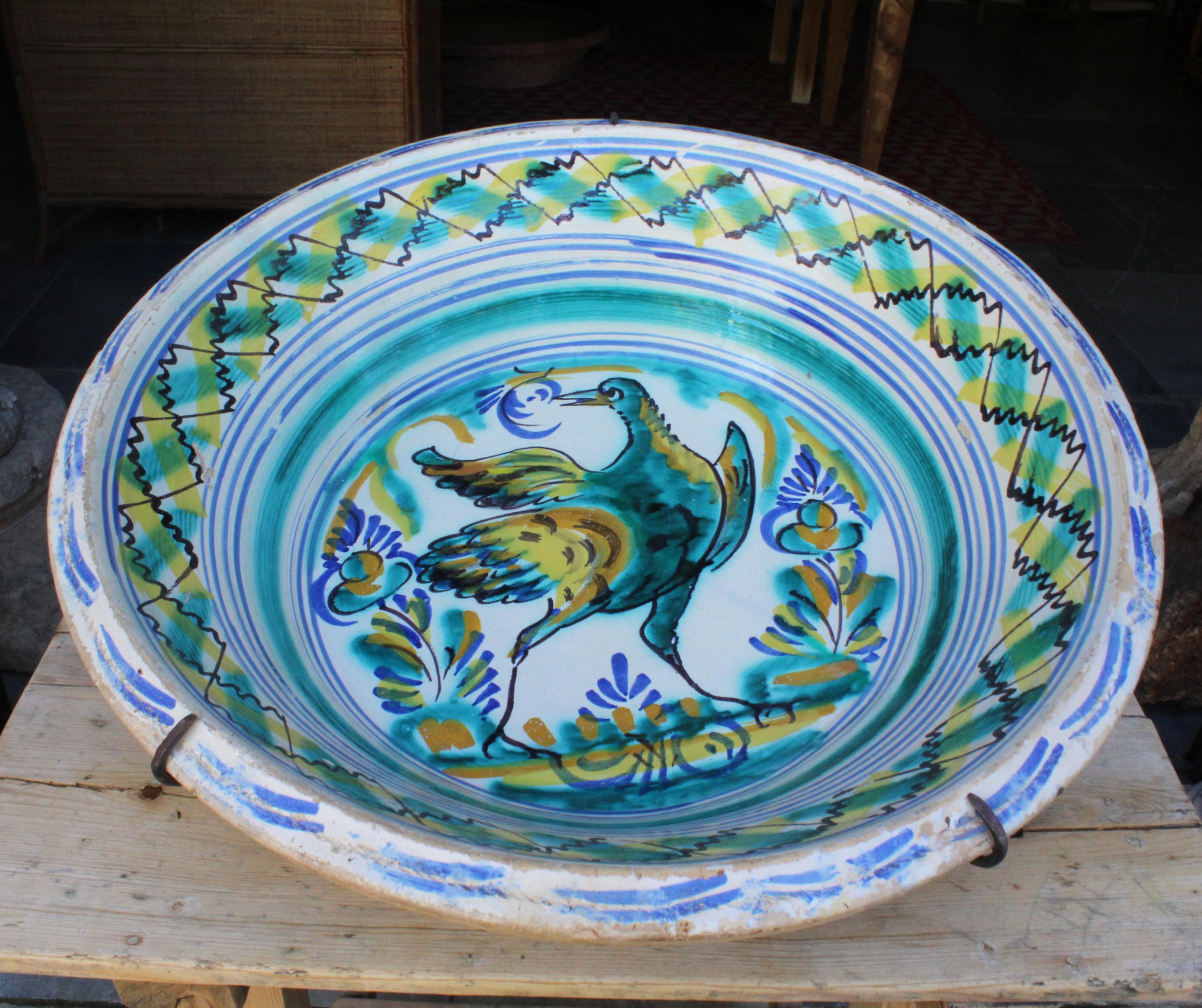 19th century Spanish Triana Whit green, blue and yellow glazed terracotta plate

Triana is a style that originates in Seville, known for its mix of Christian and Al-Andalus cultures.

With essence of a town and trees in the middle and geometric