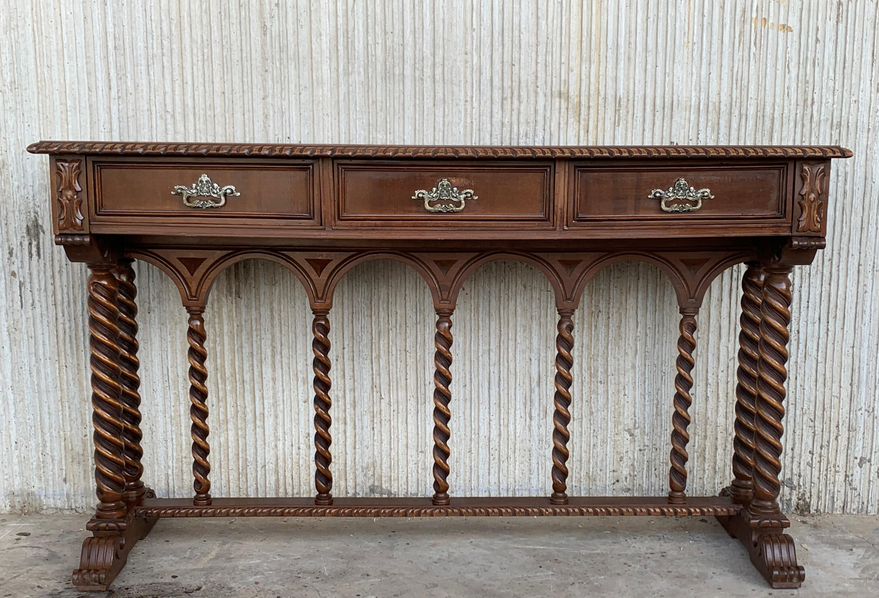 19th century Spanish console table with three carved drawers with bronze handles and solomonic columns and twist legs.