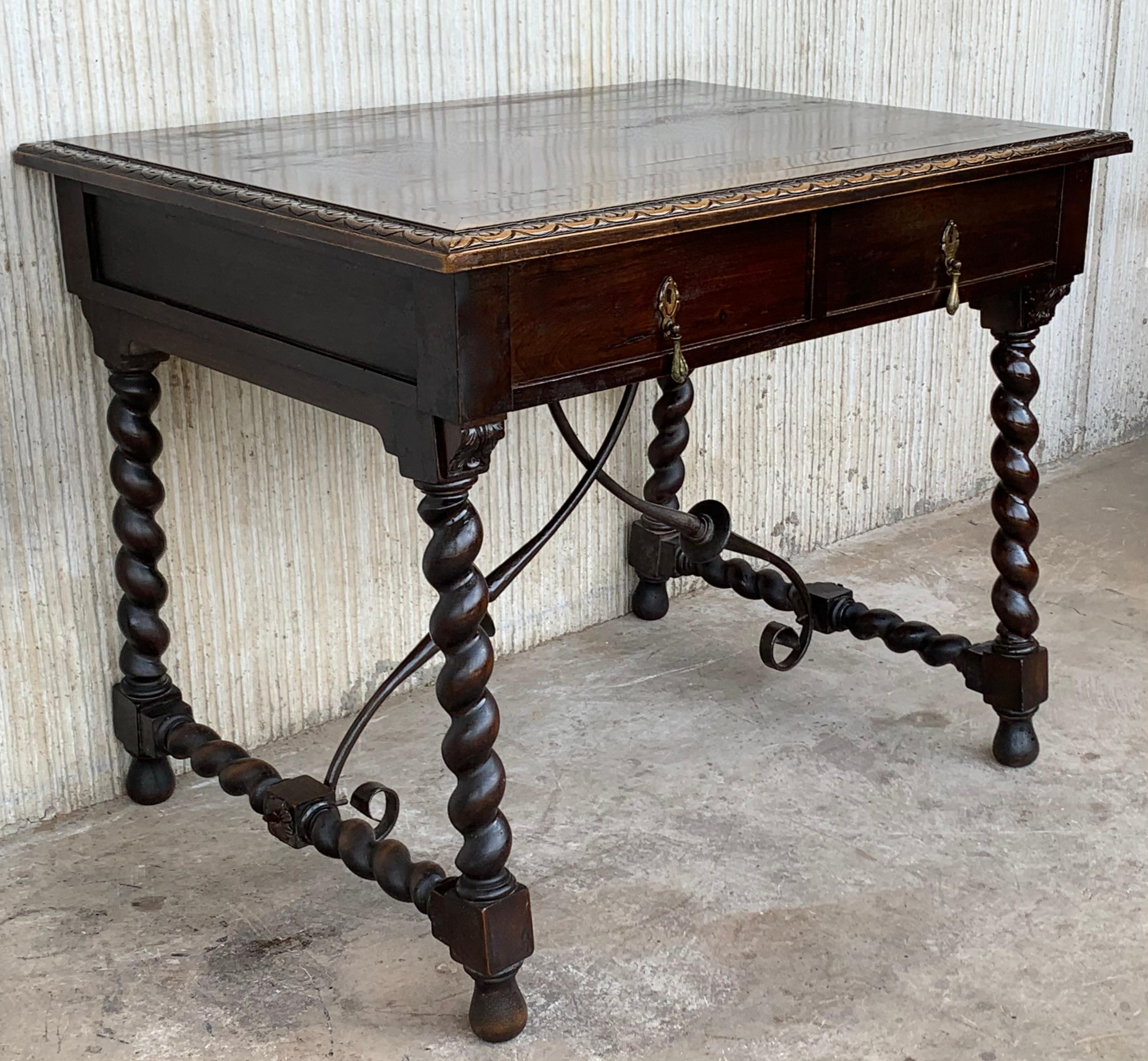 19th Spanish walnut desk with two drawers and solomonic turning legs , it has an iron stretcher between the legs.
The top is made of walnut with a beautiful carved edge.
The back of the table is carved featuring two no real drawers with