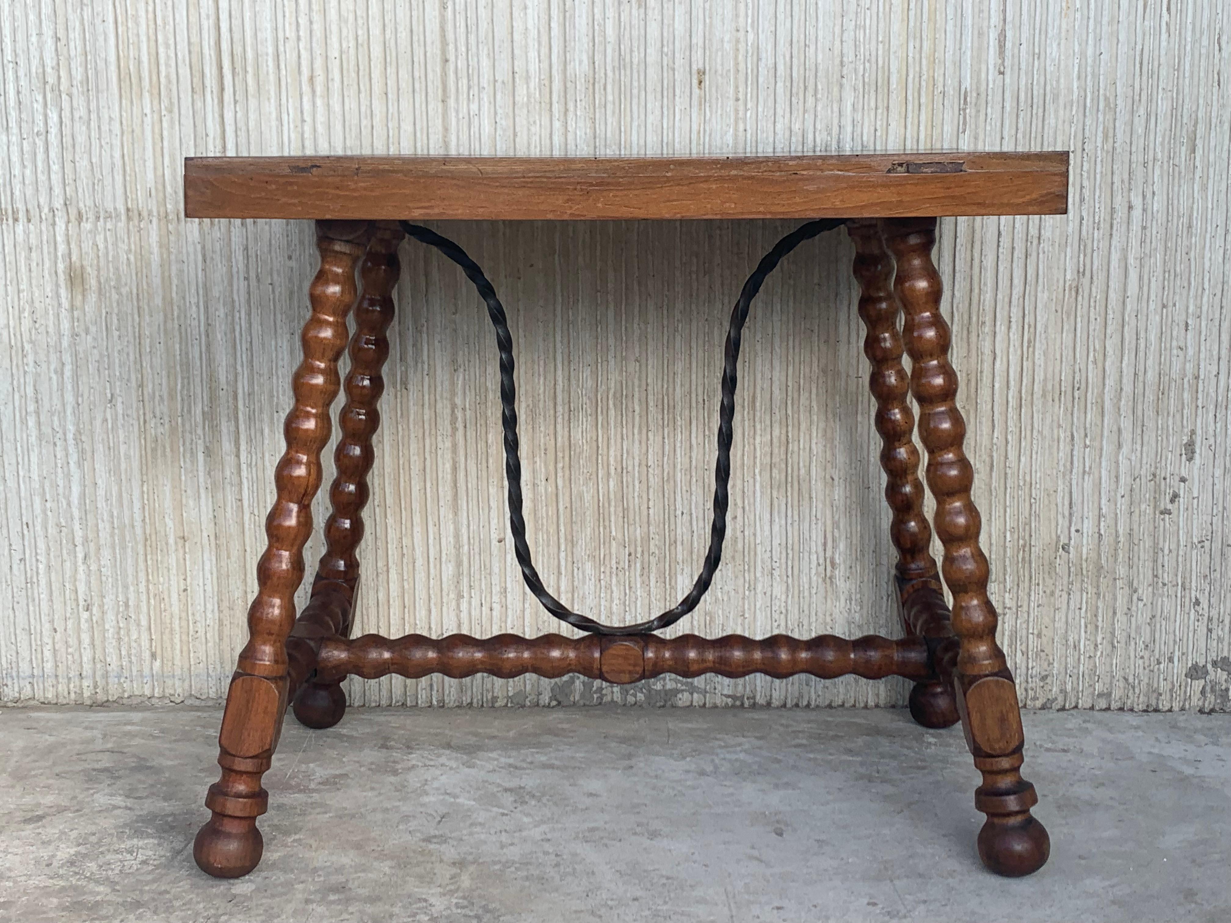 Side table of walnut with turned legs and flat top. Spanish, the legs are connected by an original iron stretcher, 19th century.