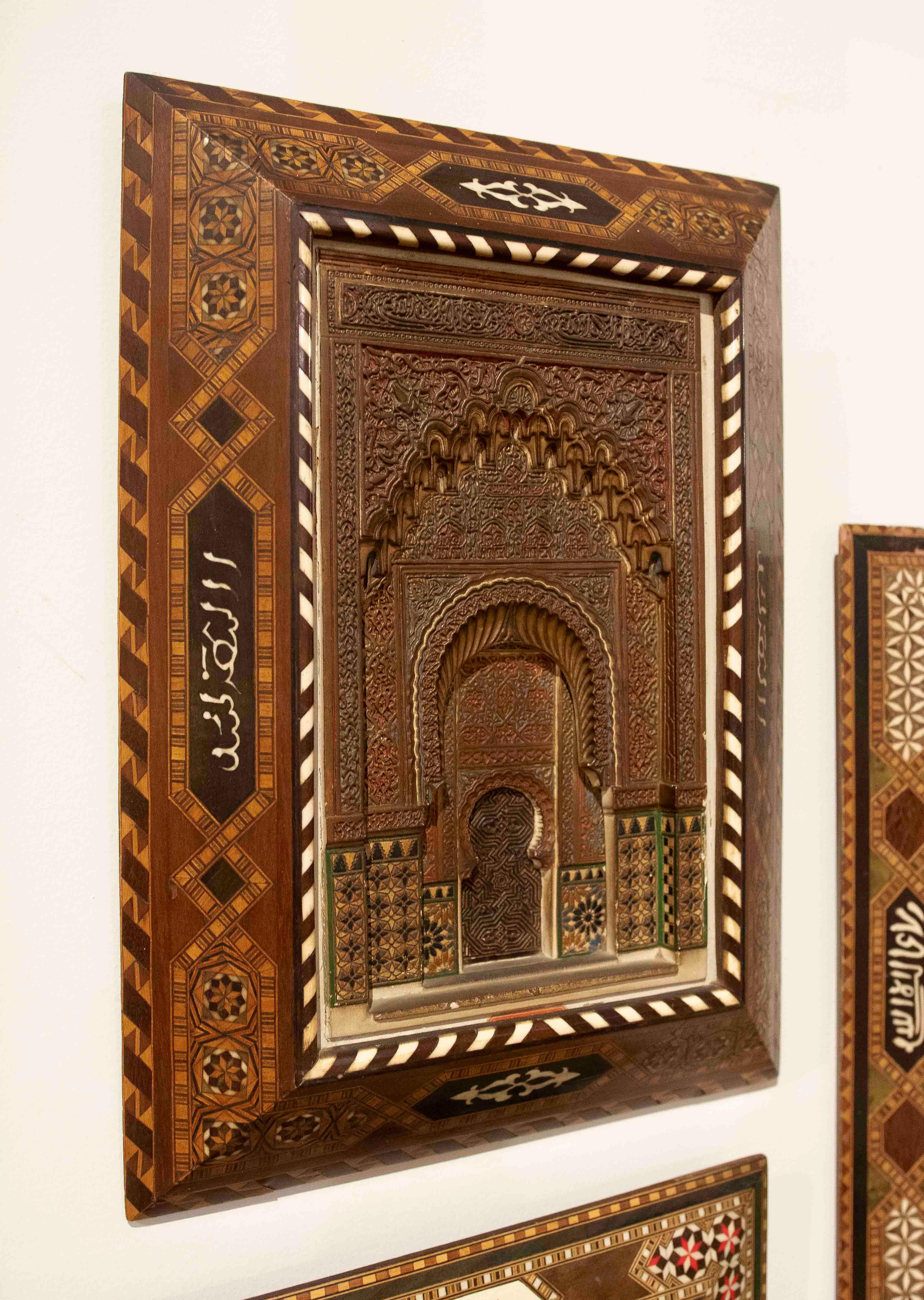 Exquisite stucco relief model reproducing a monumental arch from the Alhambra in Granada, with intricate latticework, Arabic calligraphy, and muqarnas at various depths. The palette of earthy and reddish tones highlights the ornamental richness of
