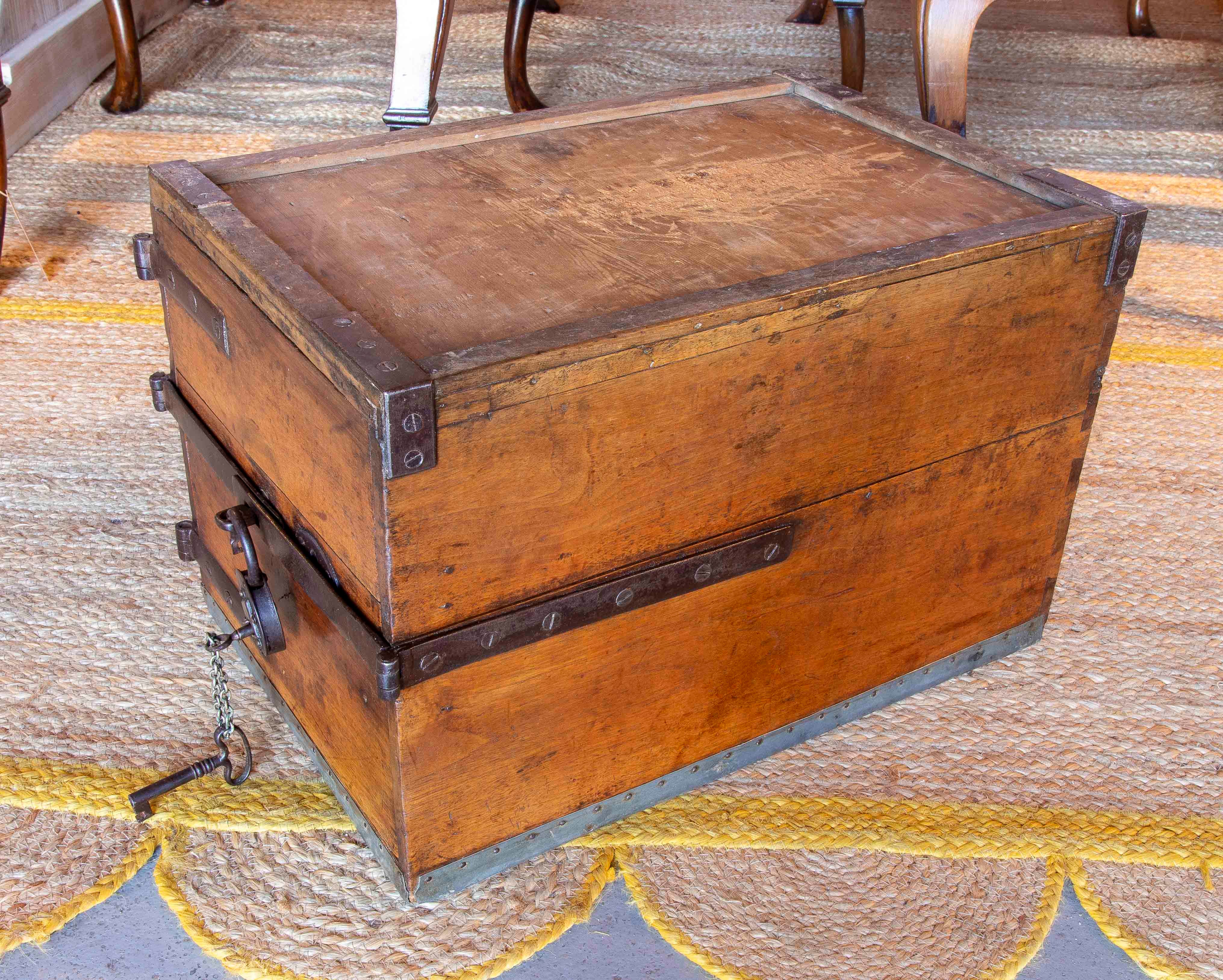Rare et robuste coffre à bijoux de sécurité du XIXe siècle en bois massif avec renforts métalliques et ferrures en fer forgé. La pièce présente une structure rectangulaire solide, renforcée par des coins en métal et une serrure frontale avec une clé