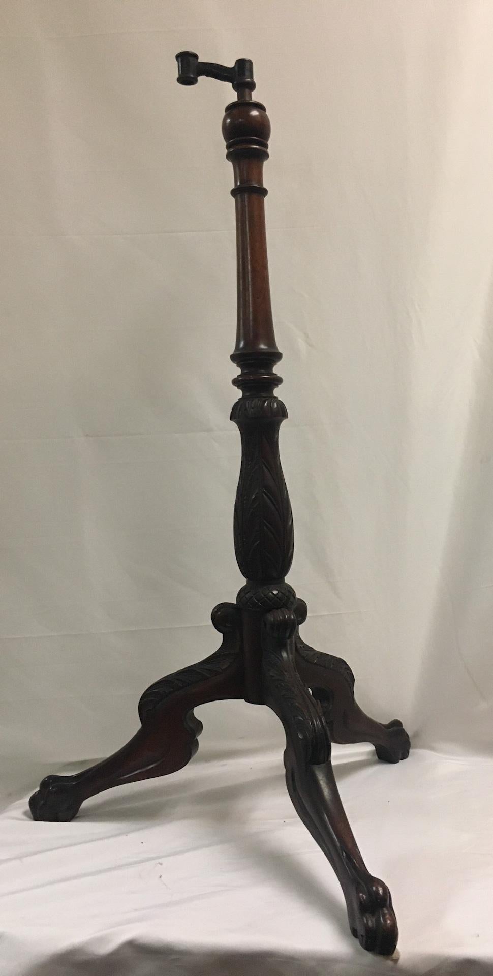 This unique floor-standing adjustable mahogany stand could accommodate both music or a book. Features include an acanthus leaf motif carved central shaft and knees on a tripod configuration terminating in paw feet, There is a a suede type material