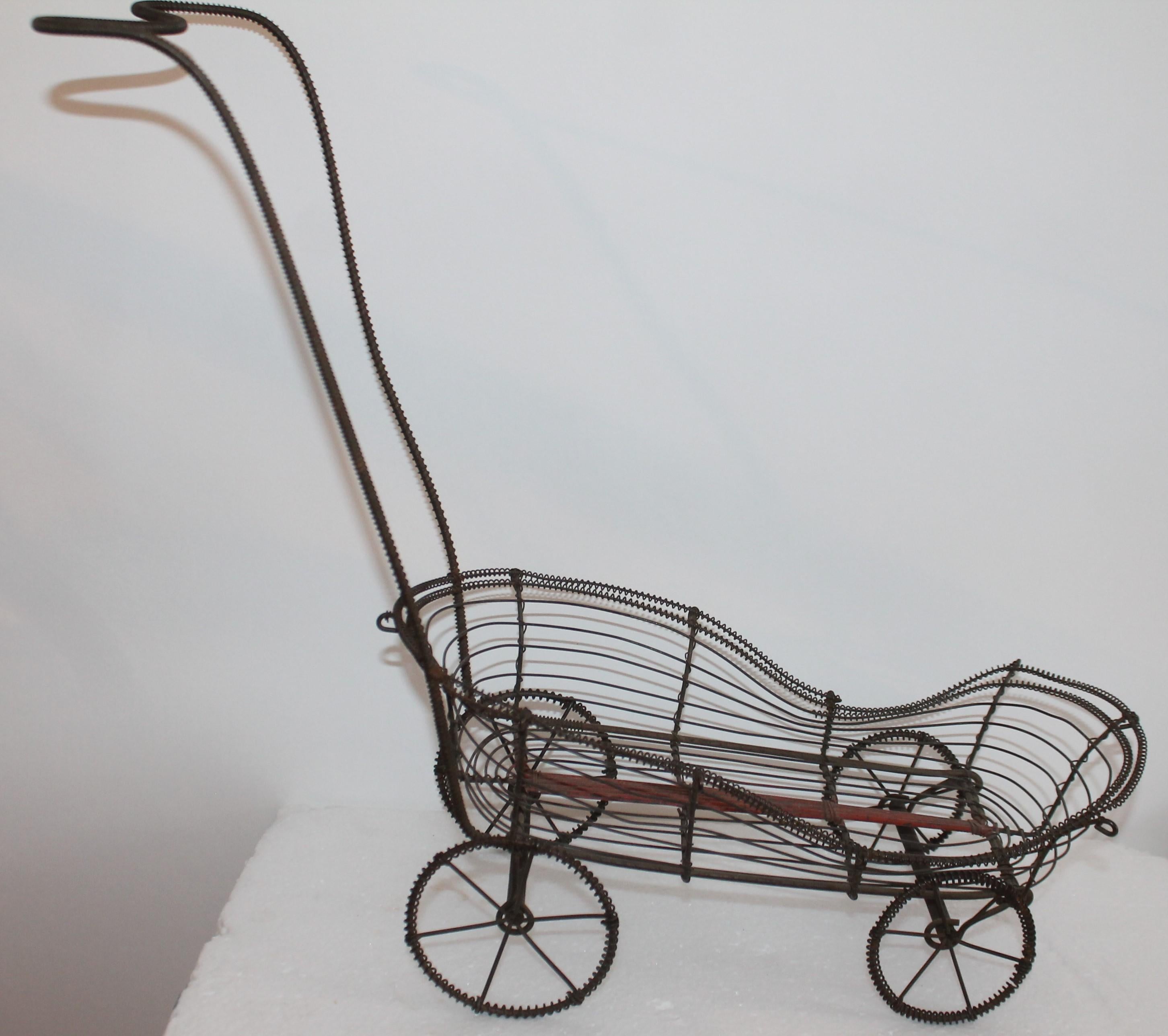 This fine folky handcrafted wire doll or teddy bear buggy is in fine condition and workable order. The wheels work and you can use this child's doll buggy.