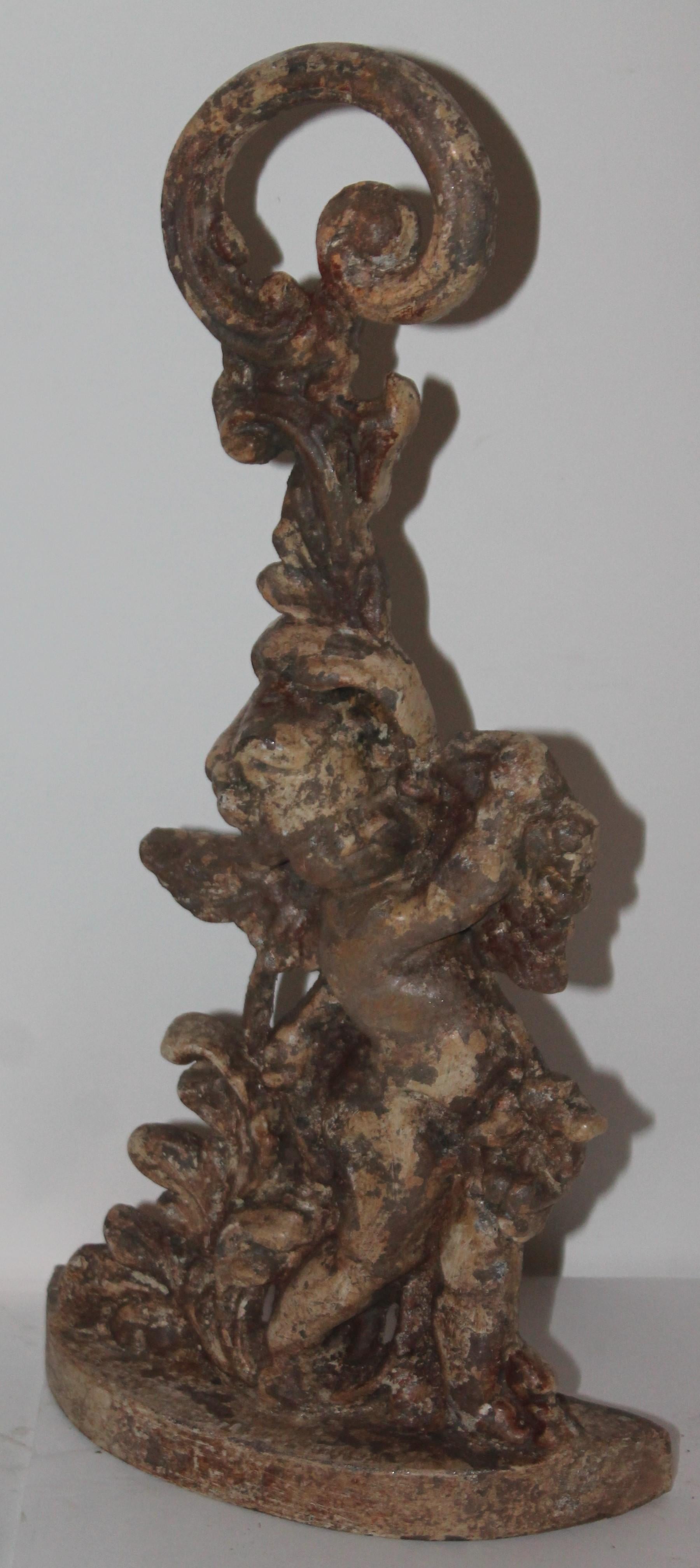 This grungy painted angel heavy cast iron door stop is in good condition. Great aged surface.