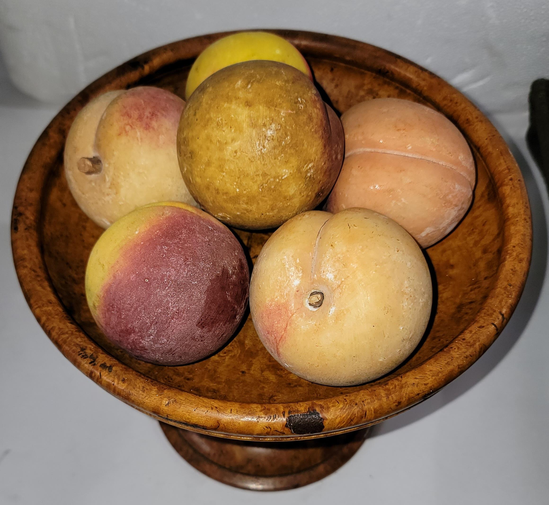 Jede Frucht misst zwischen 2,5 und 3 Zoll in der Kugelform. Es ist eine Sammlung von sieben Alabaster handbemalt Pfirsiche und ist in einem Wurzelholz oder Vogelaugenahorn Kompott in gutem Zustand.