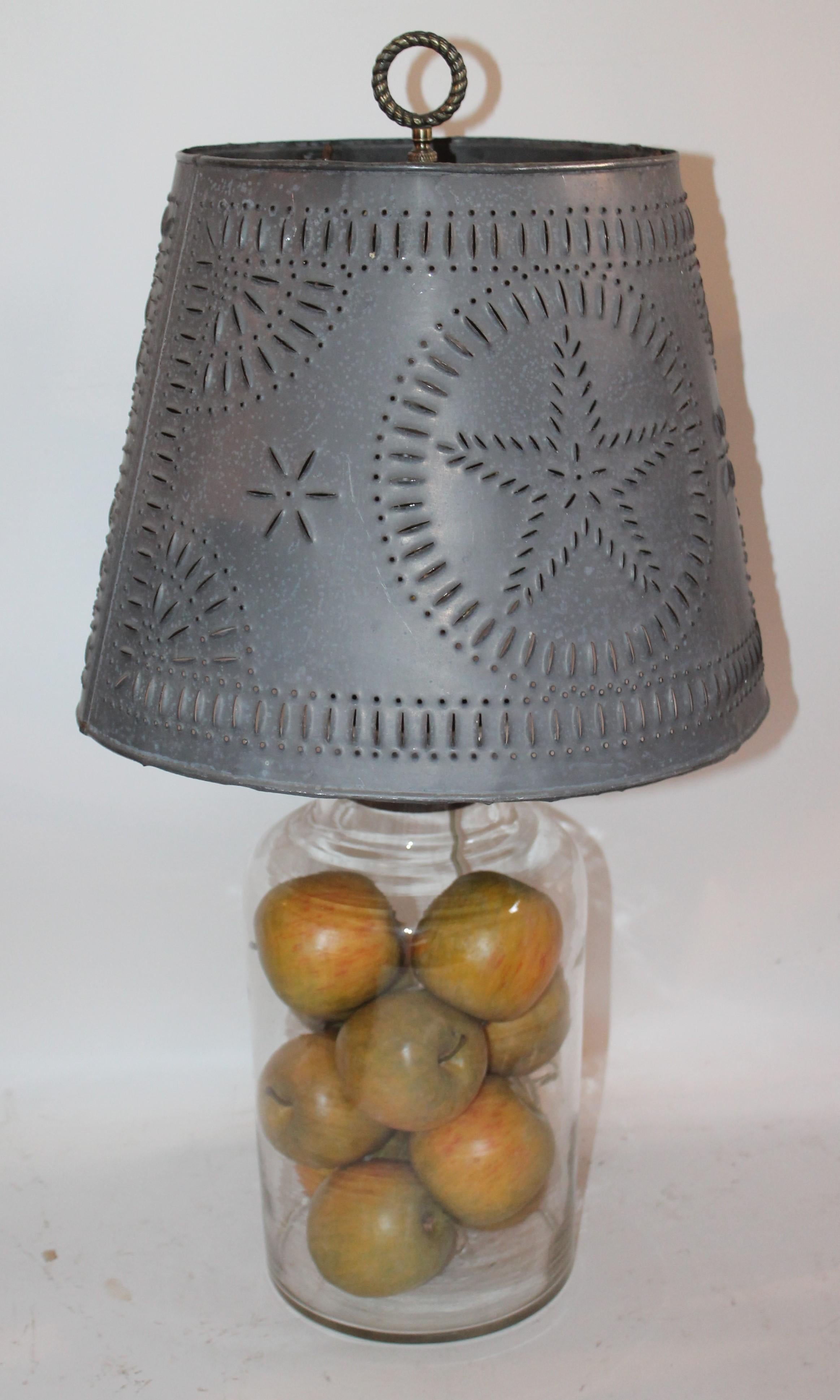 19Th century blown glass lamp for collections ( can fill with anything top lifts off ) and this old pickle jar is filled with apples, The vintage punched tin shade has nice age but not sure how old the shade is. This is a fantastic lamp base as you