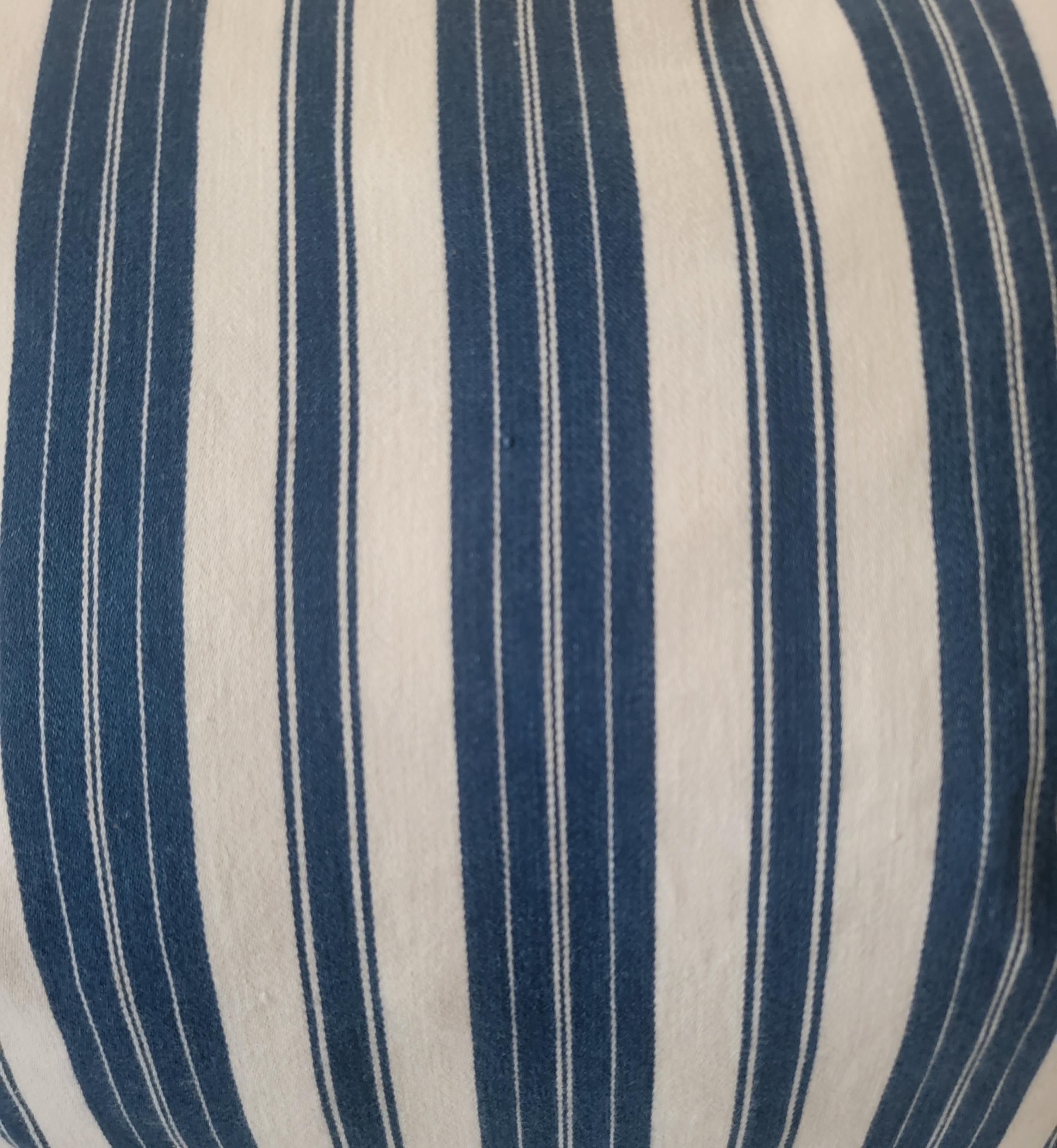 Blue and White 19thc Striped ticking pillows with linen backing and downs and feather inserts. The blue stripes are very present in this set. Strong blue color and a thick stripe make it so that the blue stripes over power the white stripes.
