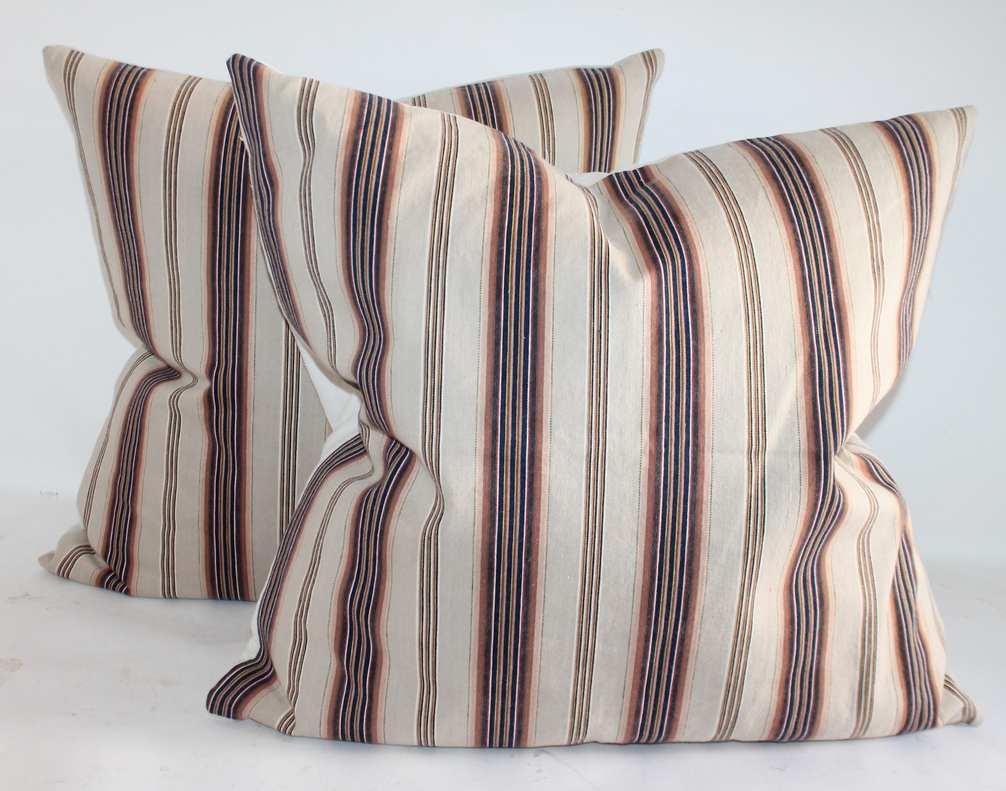 These three ticking pillows are in brown and blue wide stripe ticking with cream ground. Collection of Three pillows.
Pair measures: 22 x 22
single measures: 20 x 20.