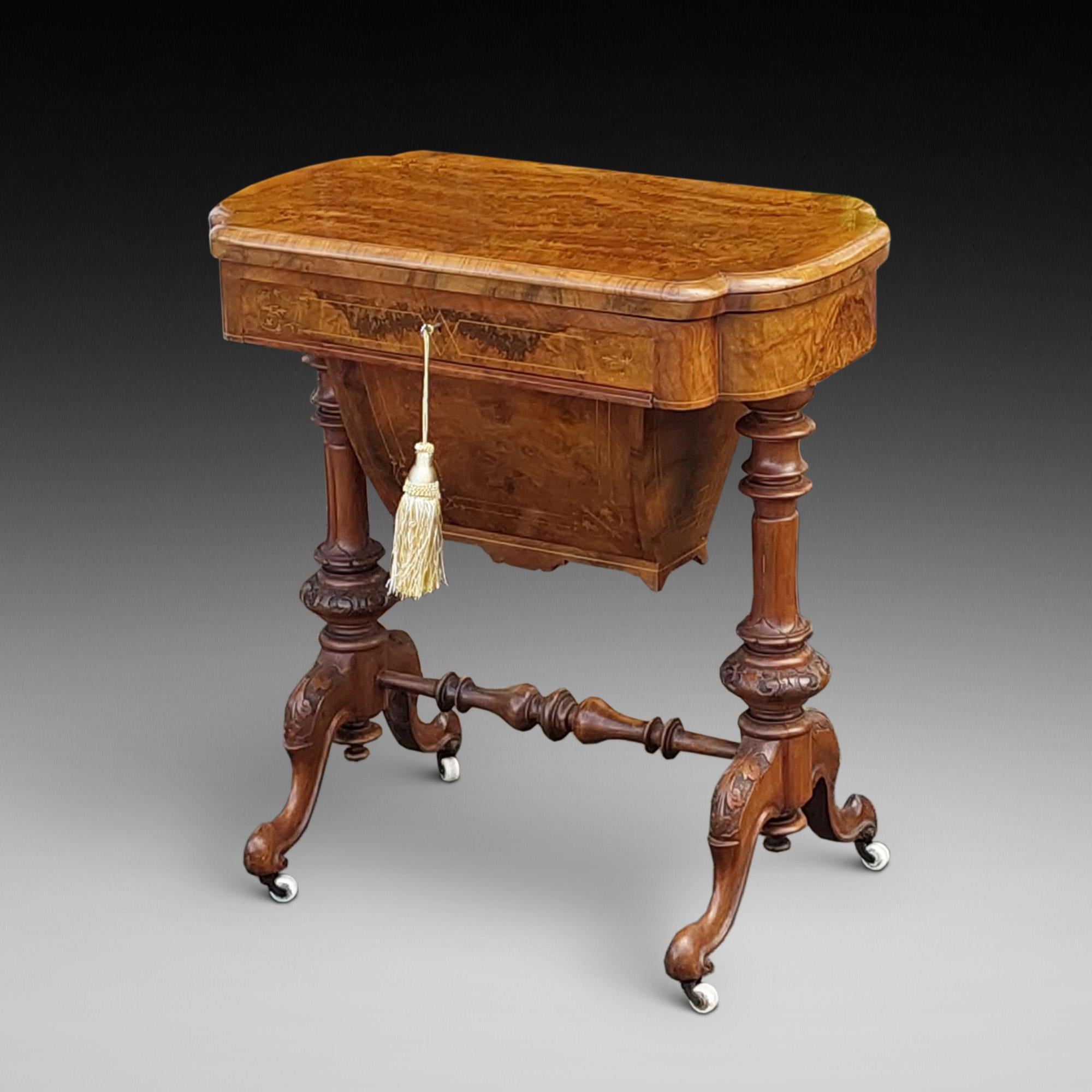 19thC Burr Walnut and Marquetry Inlaid Games/Work Table - swivel top opening to chess, backgammon and cribbage boards, over drawer with sliding basket on twin column supports united by stretcher terminating in scrolling trestle bases with ceramic