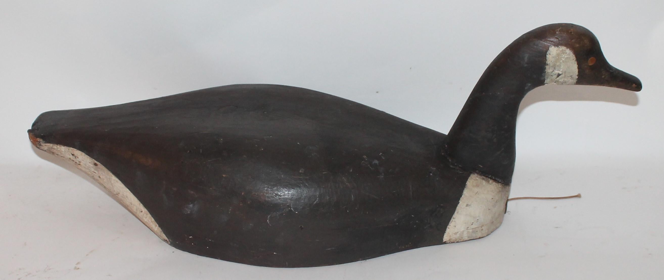 This fine hand carved and original painted Canadian goose has a wonderful patinated surface and great form. The condition is very good and has shrinkage crack on the base consistent from age and use. Notice the form of the tail end and fine carved