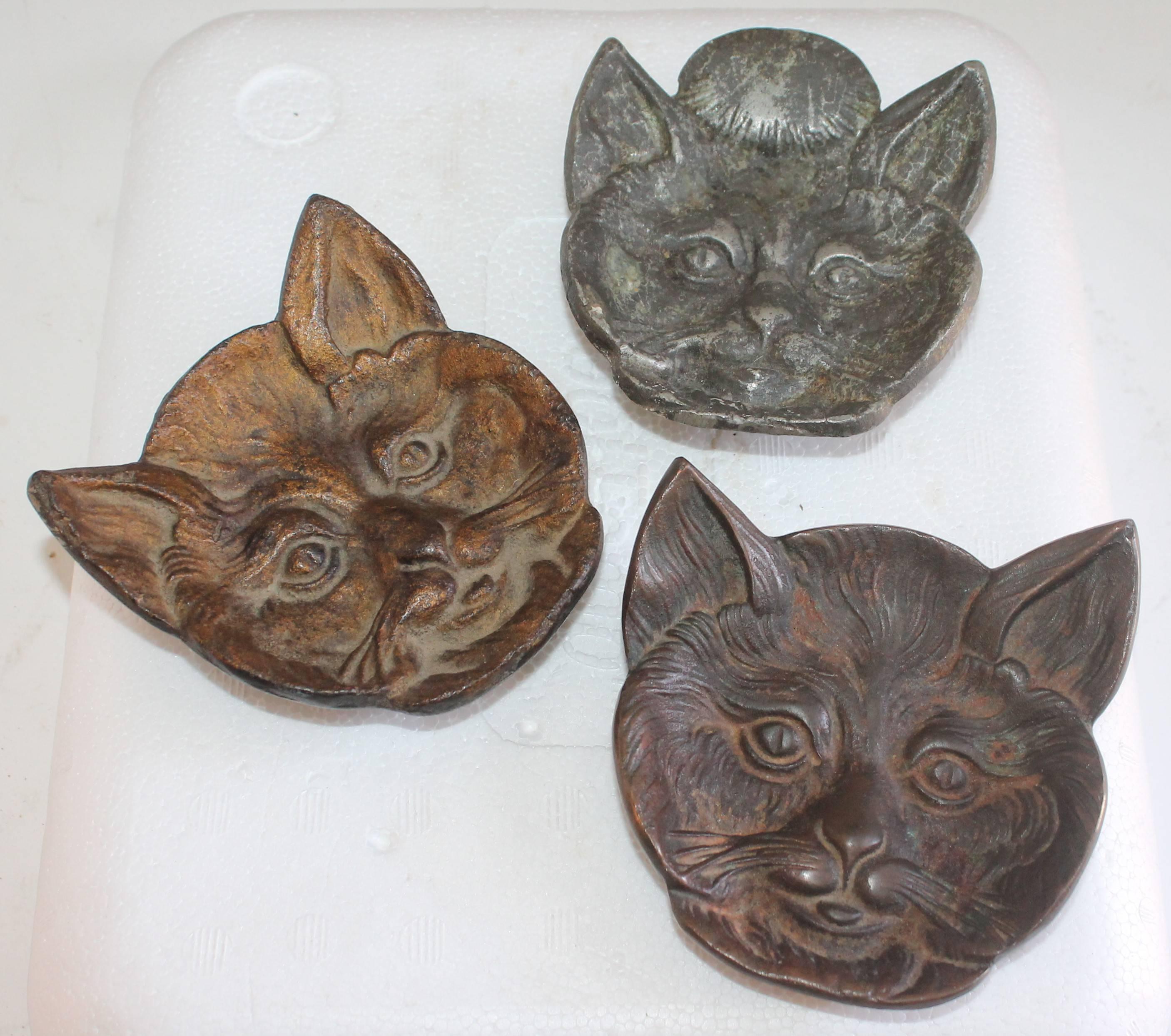 Collection of three 19th century cast iron cats trays. These cats look like they were a give away from some iron works company. Perhaps a pot belly stove or old iron forger. They have a wonderful aged patina and all three are slightly different