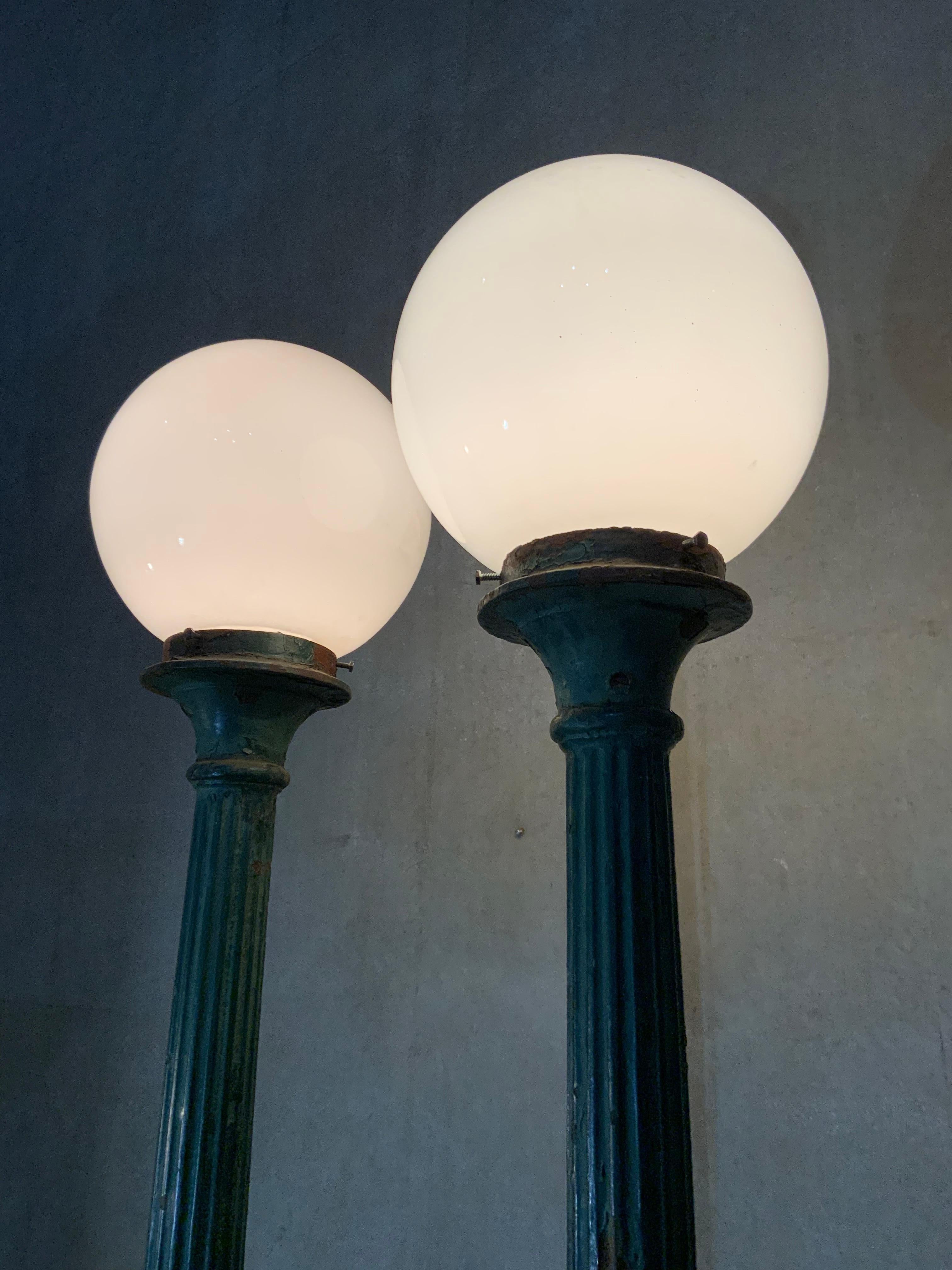 A very nice pair of fluted cast iron lamp posts from the east coast USA with glass globes and rewired condition. Finish has remained in old oxidized green paint.

Very unusual size.