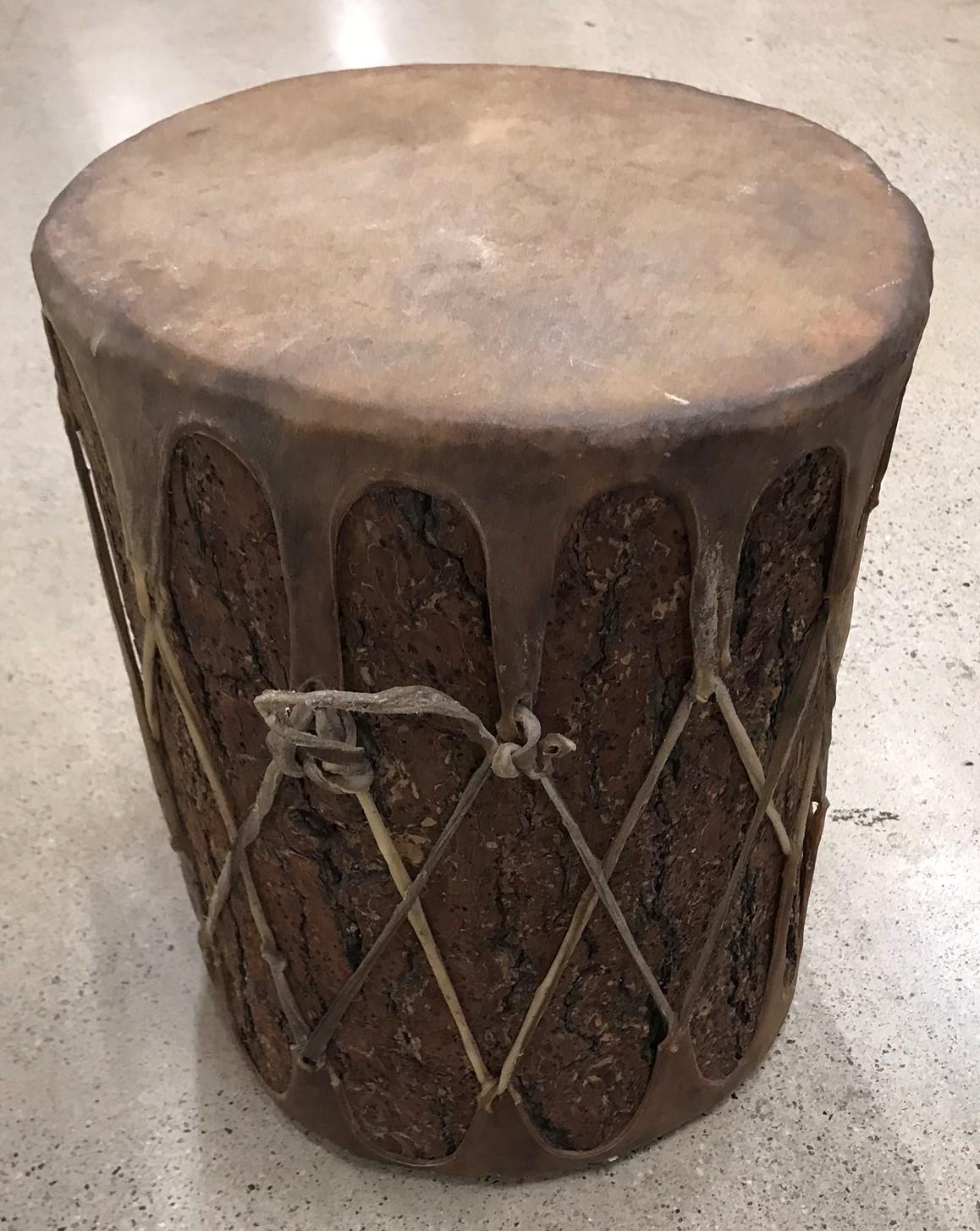 This fantastic early handmade bark covered drum has the original hide covering and in great condition. Has a wonderful aged patina.