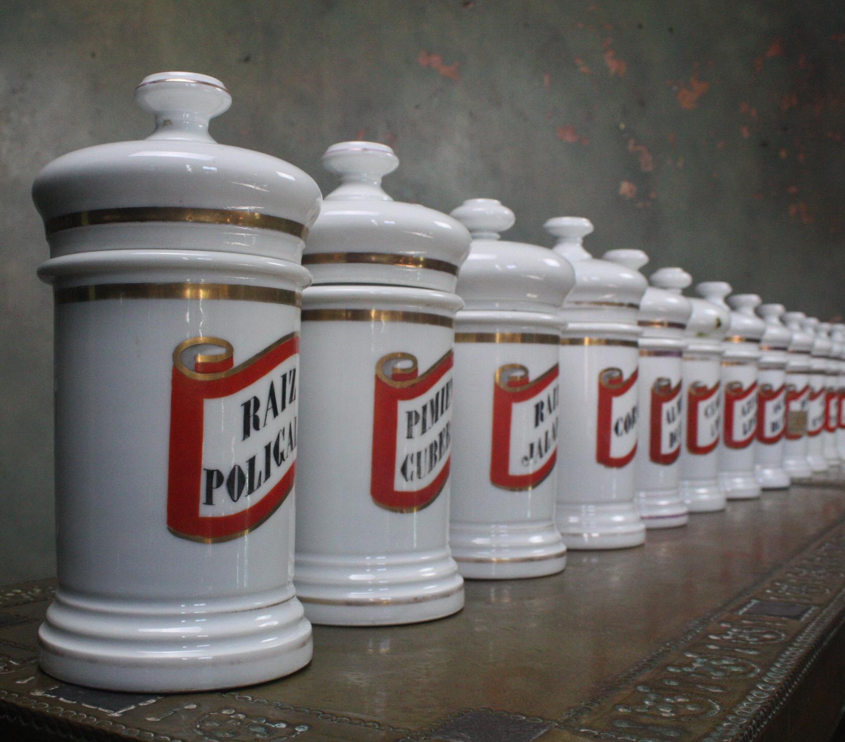 Rare collection of 22 ivory white stoneware dispensing jars. These where removed from a chemist in Barcelona, a number of them did have there original contents (now removed). These jars where used to hold dry goods, circa 1880s in age. 

The jars