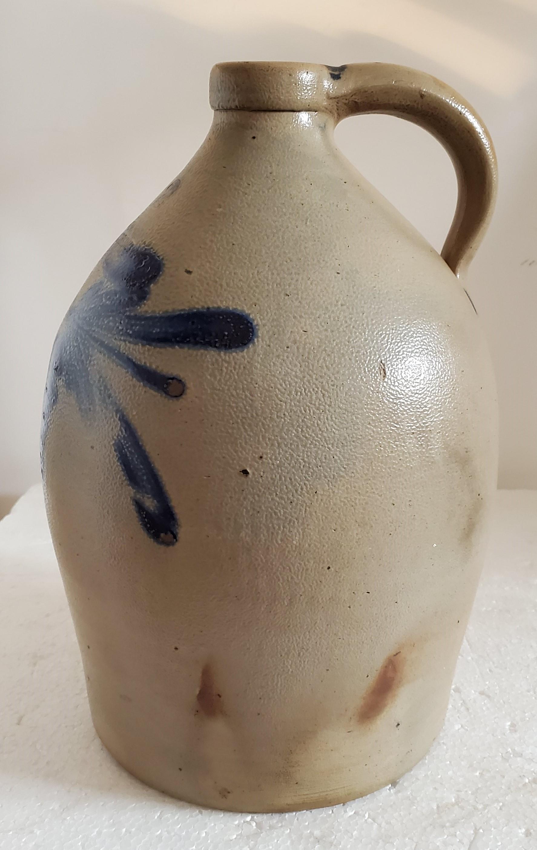 This fine blue 19th century decorated stoneware two gallon Cowden & Wilcox jug is in fine condition. This heavy flower design is quite unusual. Condition is mint. This was made in Harrisburg, Pennsylvania.