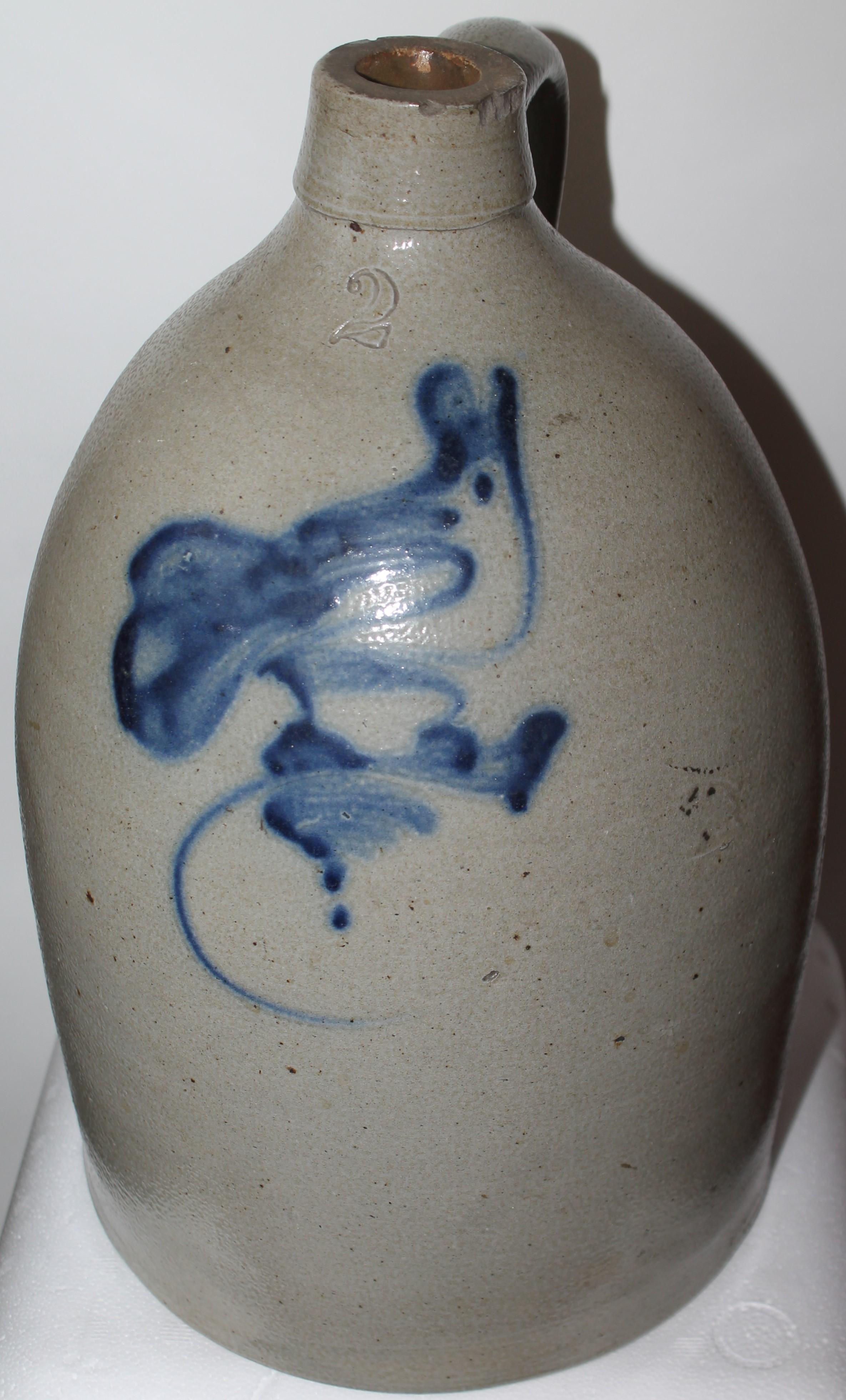 19th century decorated stoneware jug with a bird on the face. This is a New York State jug. The condition is very good.