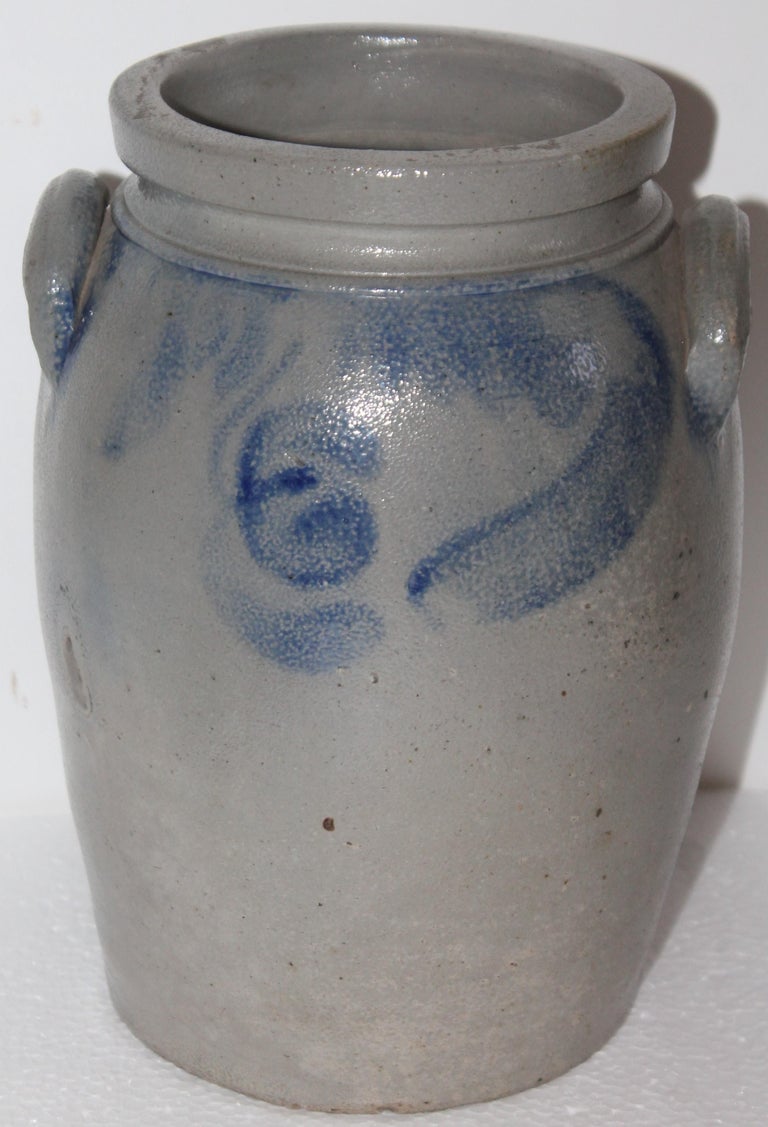 This highly decorated stoneware crock is in fine condition and has double handles. This is decorated all the way around. It was found in Pennsylvania.