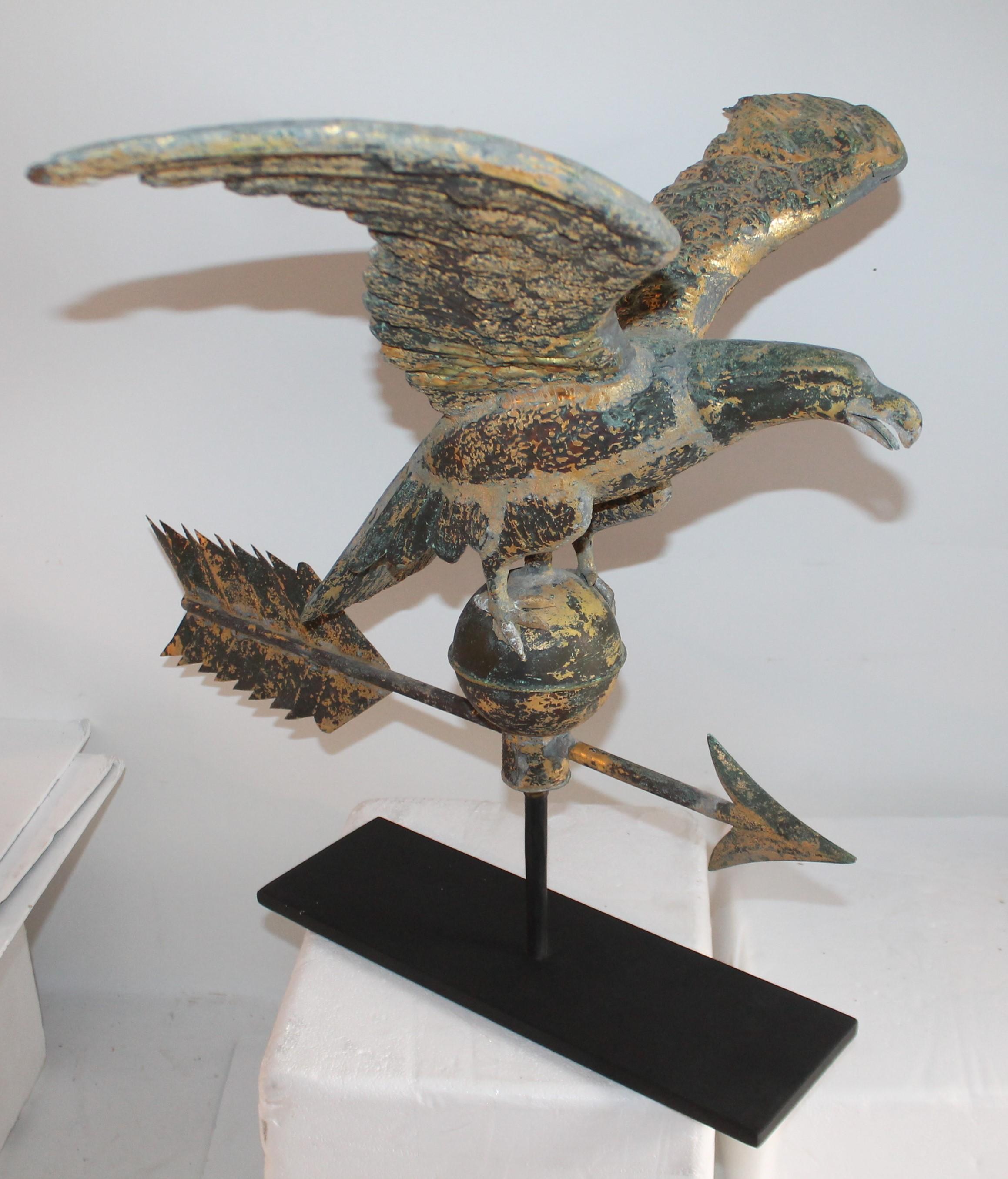 This 19th century original gilded full body eagle weather vane from New England is in amazing old surface and mounted on a custom made iron base. The left wing has a minor dent or bend on wing. The condition is very good and no bullet holes or other