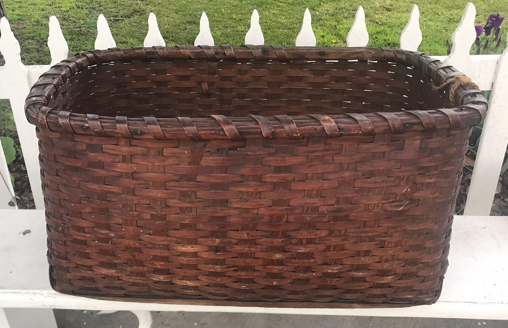 19th century early gathering basket From New England in very good condition. Minor loss on top reverse side of basket. This monumental basket has a wonderful aged patina and never had handles. It is very nice interesting construction with finger