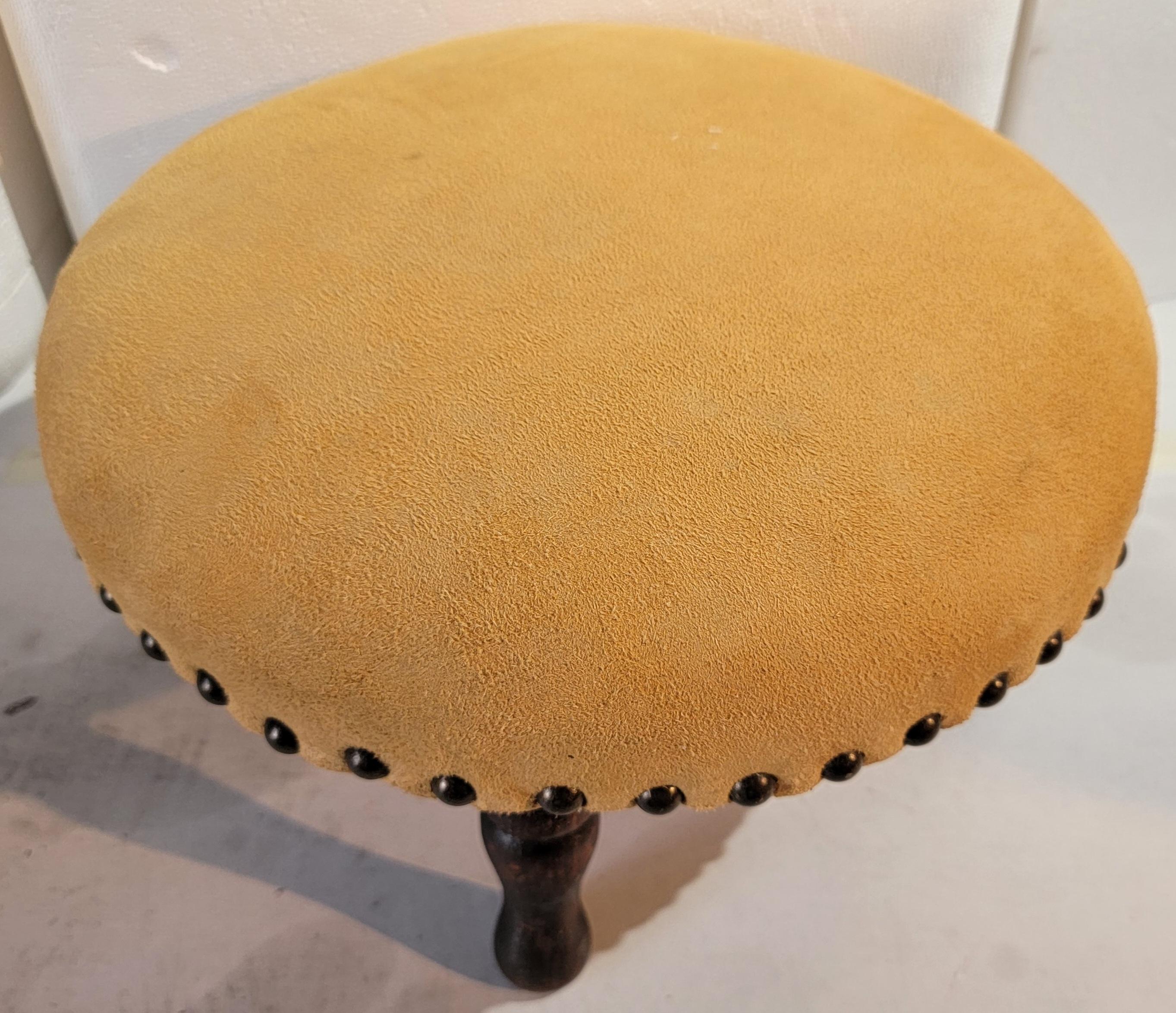 This early 19thc round foot stool with suede / leather top was found in New England. This early stool has early original turned legs and very sturdy.