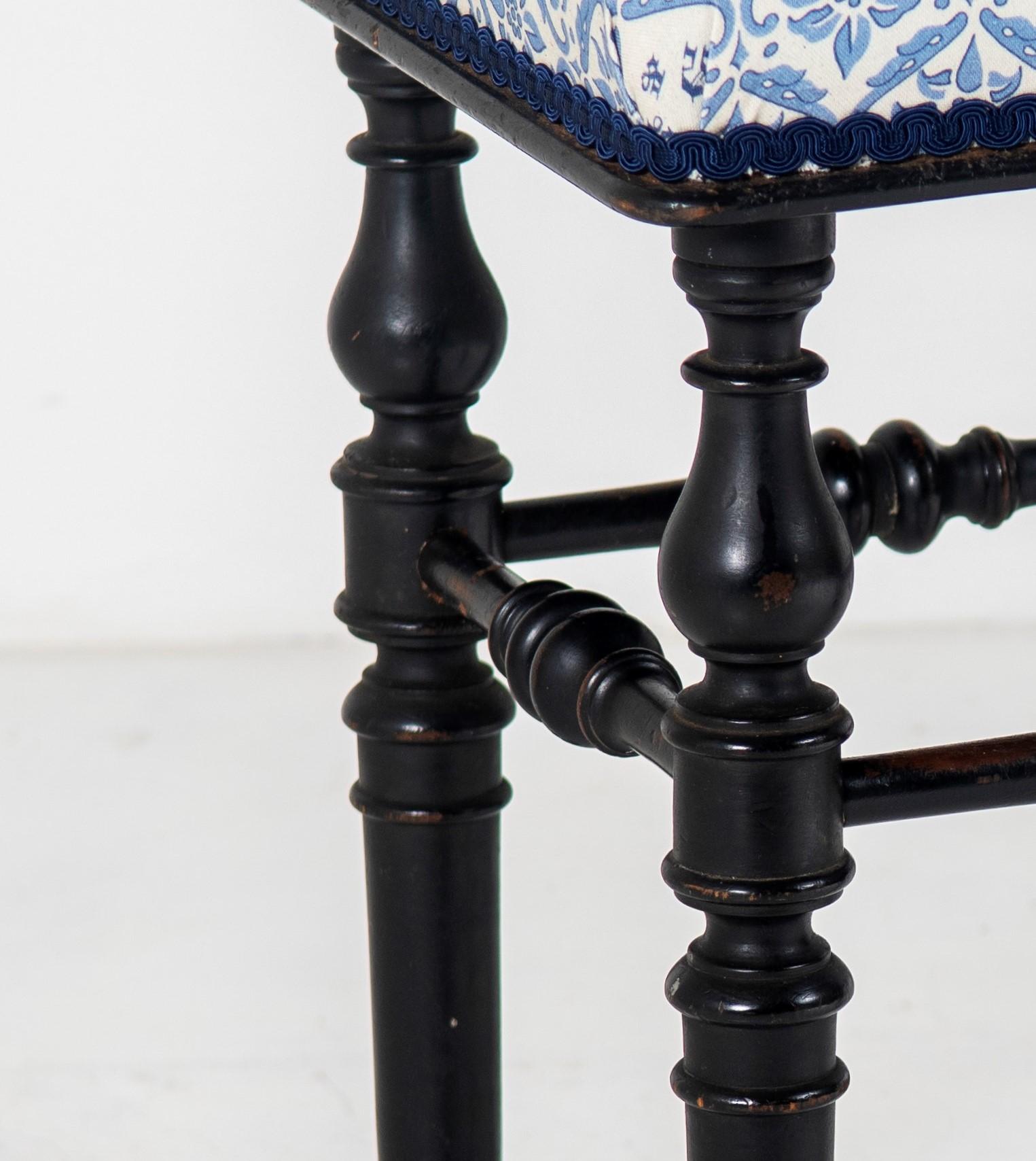 An ebonised piano stool by Henry Brooks & Co London. Beautifully made, well proportioned stool with cushioned seat leading to four turned legs with hoof like feet and delicate turned stretchers.
Re-upholstered in a classic Howard & Sons fabric to