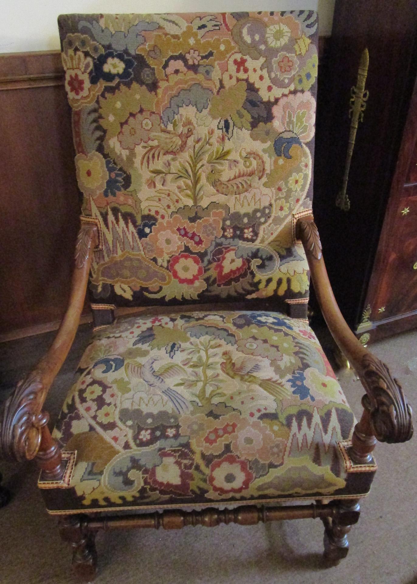 This elegant Jacobean Revival English oak armchair features hand carved acanthus leaves on the upper and lower sloping arms. The front legs and stretchers are also expertly hand carved.
It is upholstered in colorful petit point and needle point with