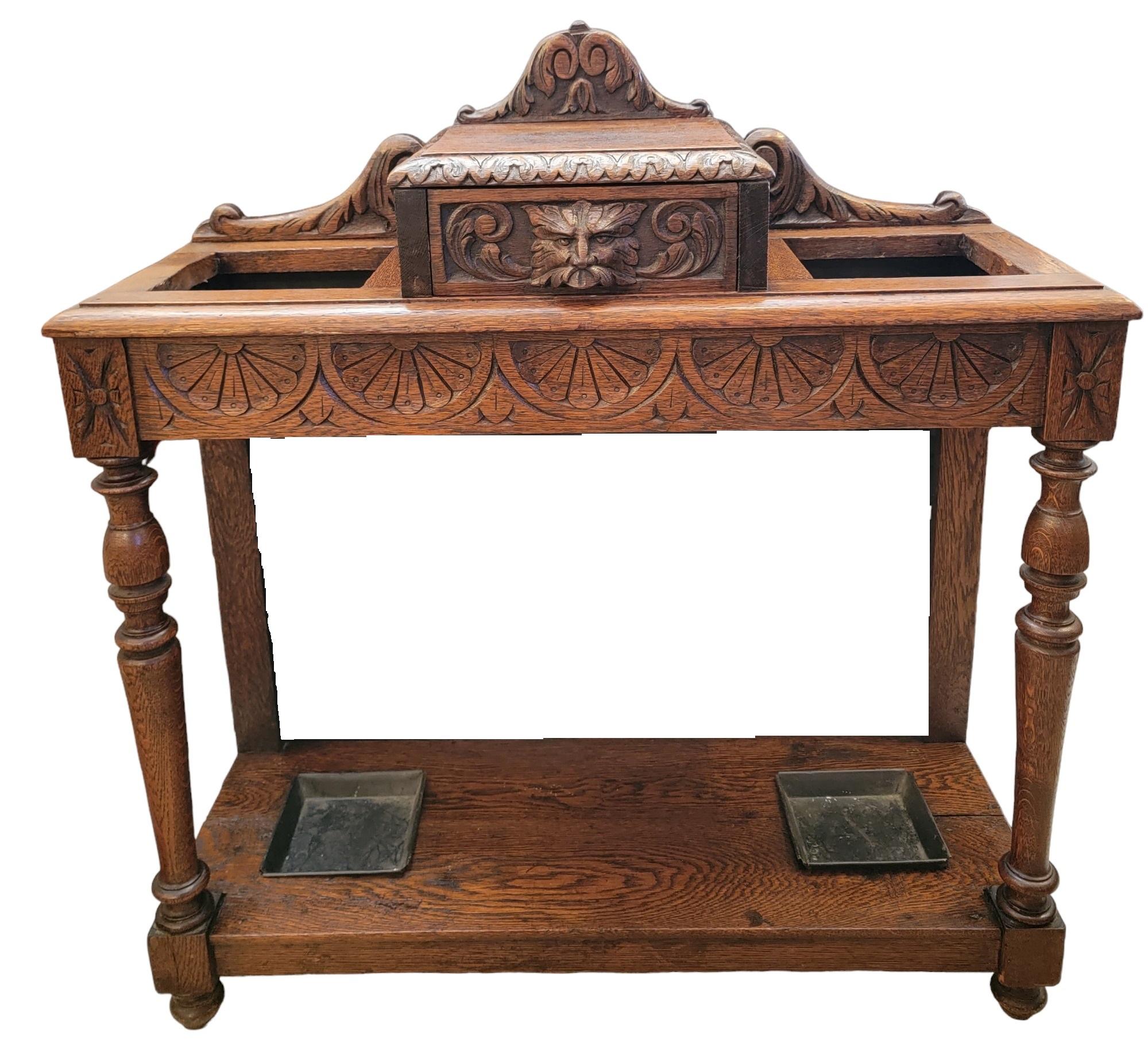 19thc English Oak Umbrella Console Table. has two square cut out perpendicular to one another on each side. The bottom cut out has a metal tray to hold the umbrellas up and when used to catch and liquid that may drop off of the umbrella. May be used