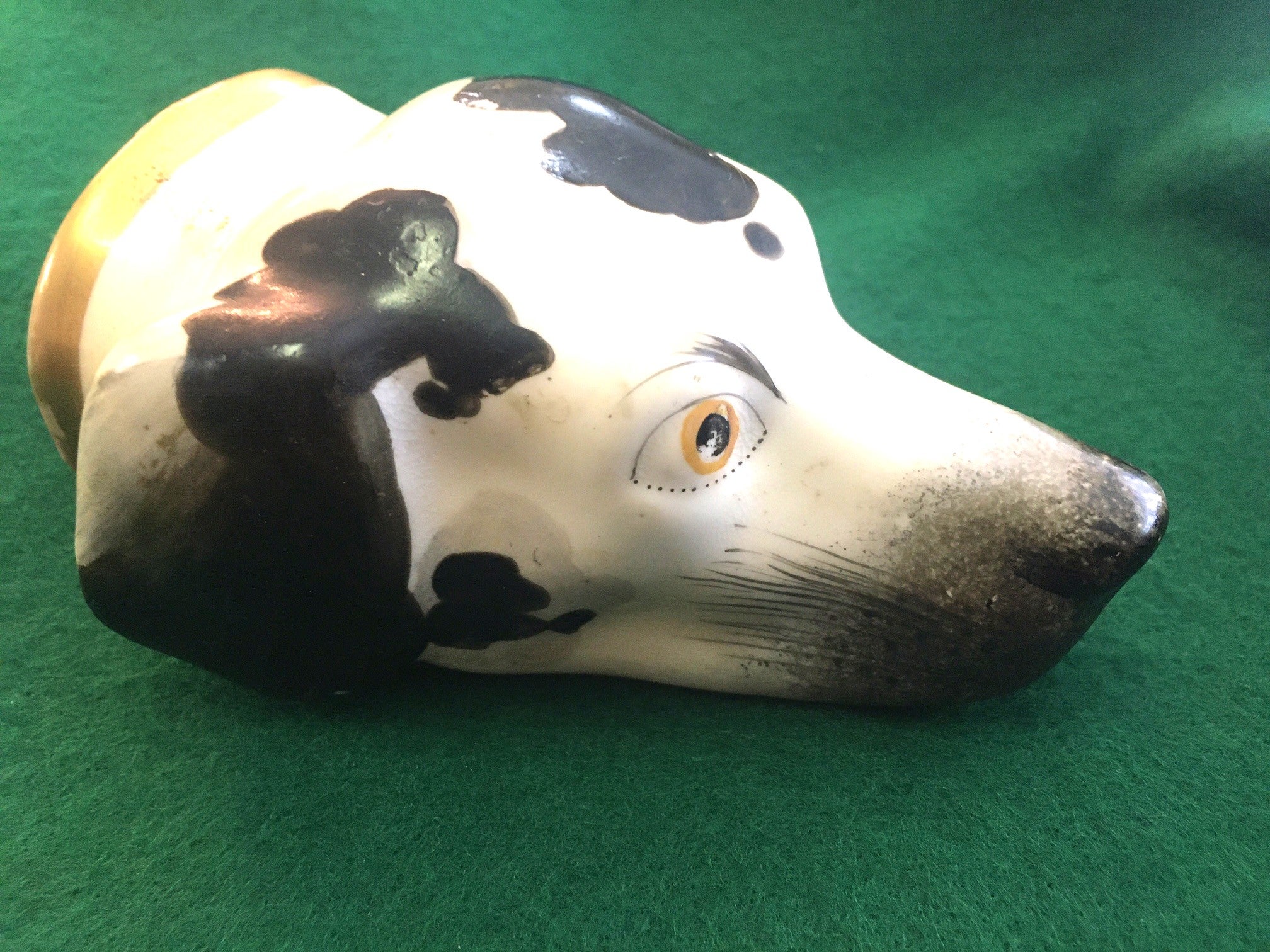 
 This charming fellow is an English porcelain stirrup cup in the form of a hound's head. He is very detailed including naturalistically modelled features, white, gray and black markings, yellow eyes with stippled eyeliner, a red mouth, feathered
