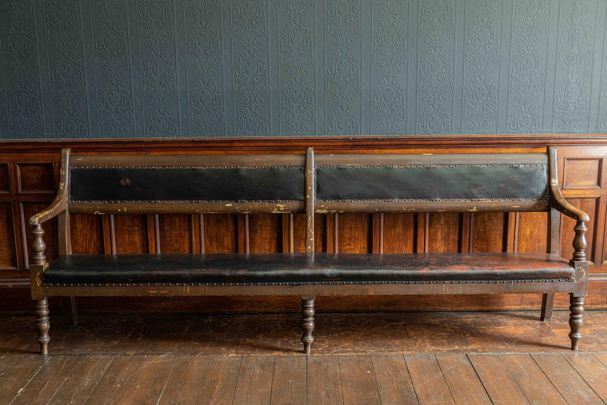 19th century English waiting room / tavern bench,
circa 1890.

In its original finish with lovely wear to the timber and in its original Oxblood studded Rexine which has the obligatory scuffs here and there all adding to this long comfortable and