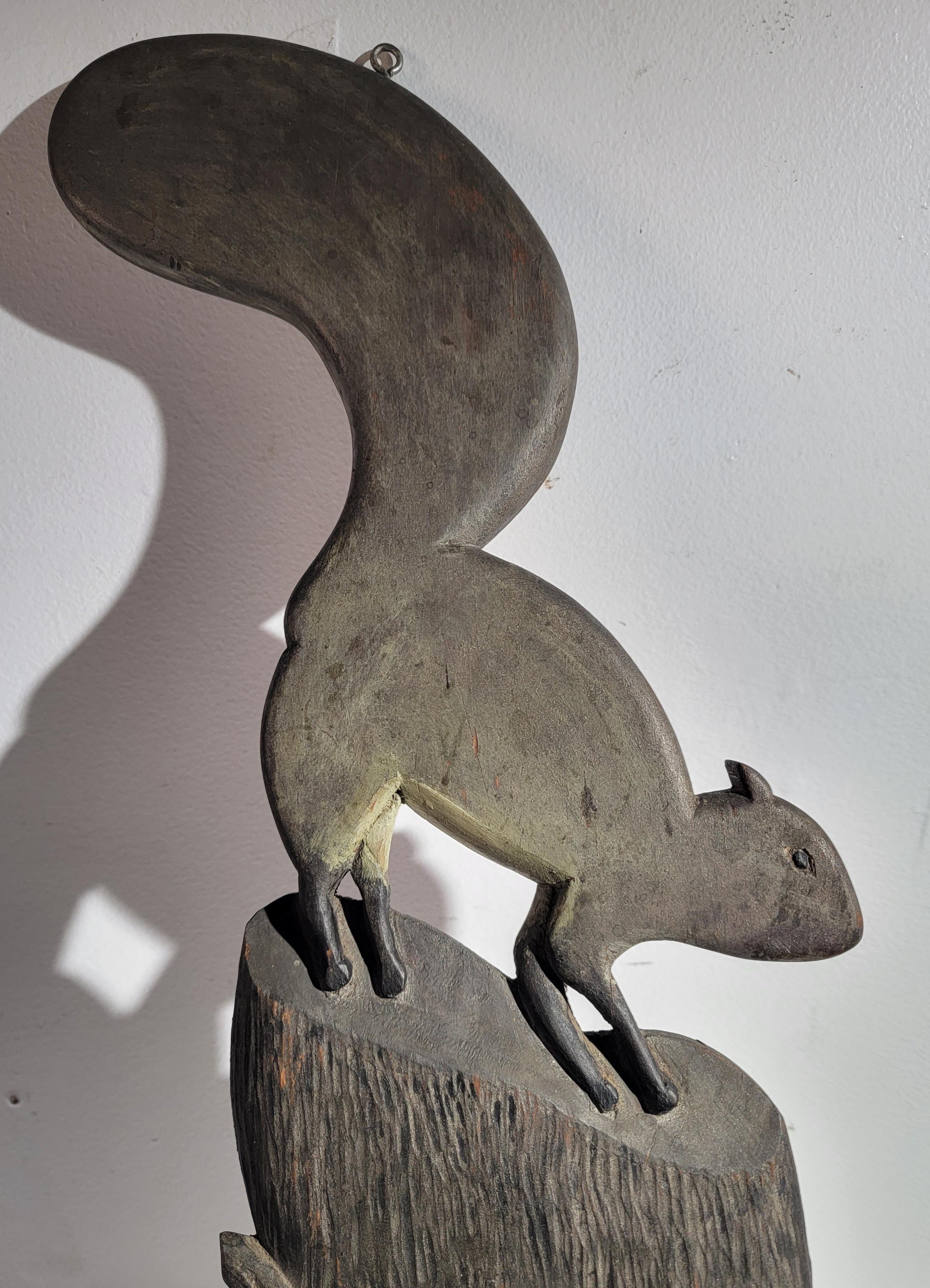 Cet étonnant écureuil en bois sculpté à la main est assis sur une souche ou un rondin. Sa surface peinte est entièrement d'origine et présente une surface croustillante étonnante. Sa surface est peinte en gris.