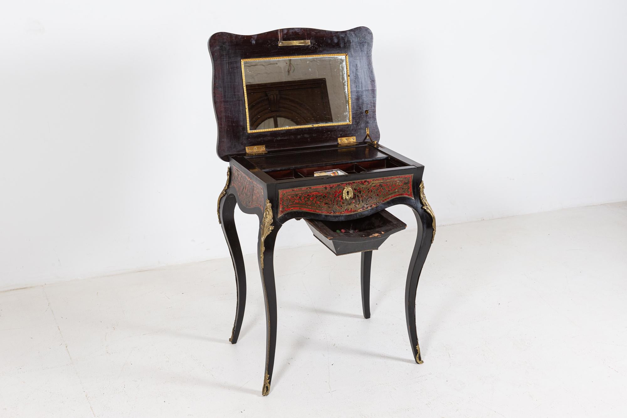 Circa 1850

19thC French boulle work / dressing table

Serpentine shaped top with a central inlaid chariot and scroll surround opening to reveal an interior with a mirror and slide out tray above a faux frieze drawer, sabre legs and a hanging