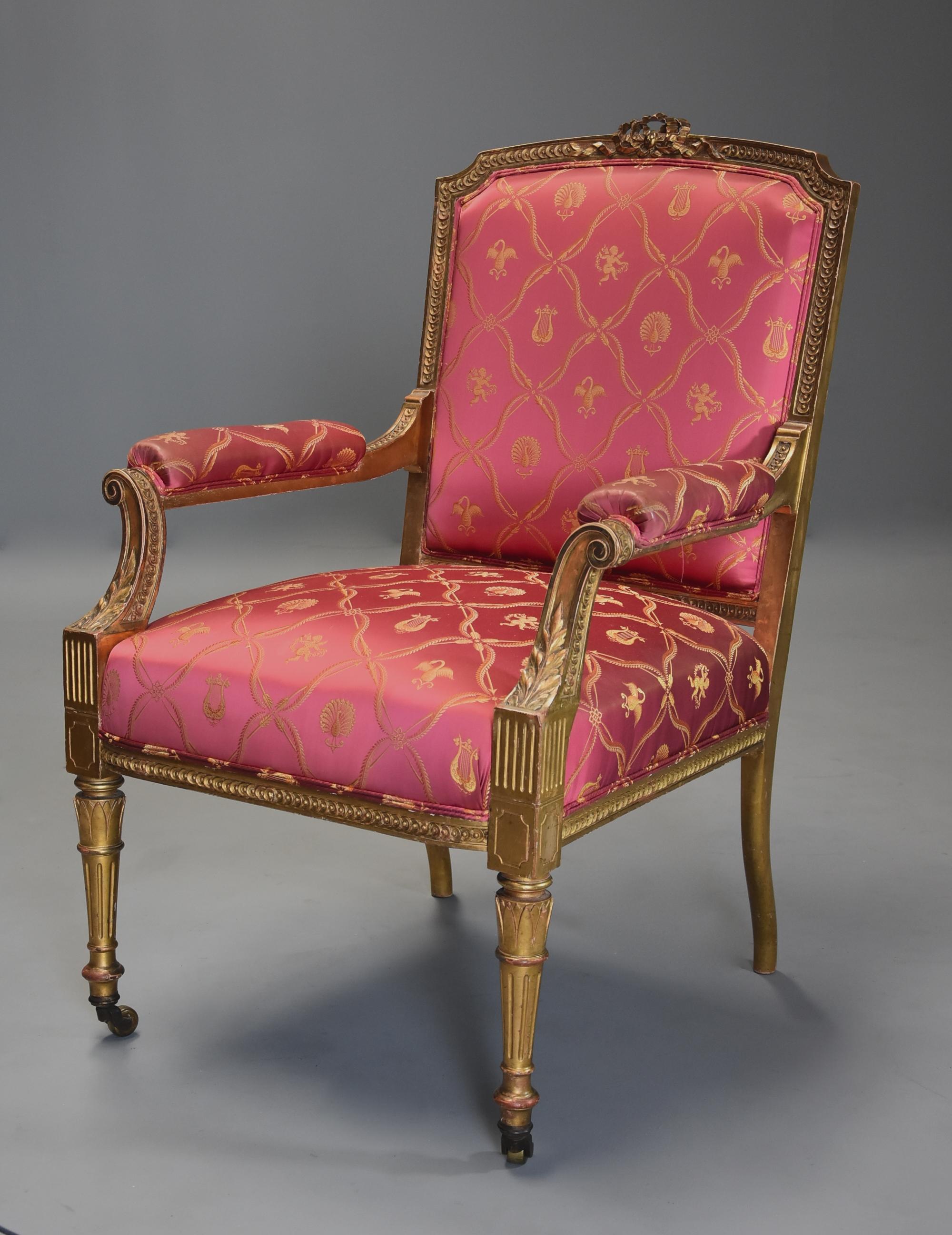 A late 19th century French carved giltwood fauteuil or open armchair of large proportions.

This chair consists of a carved top rail with ribbon design and carved circular decoration both to the top and uprights with an upholstered back.

This
