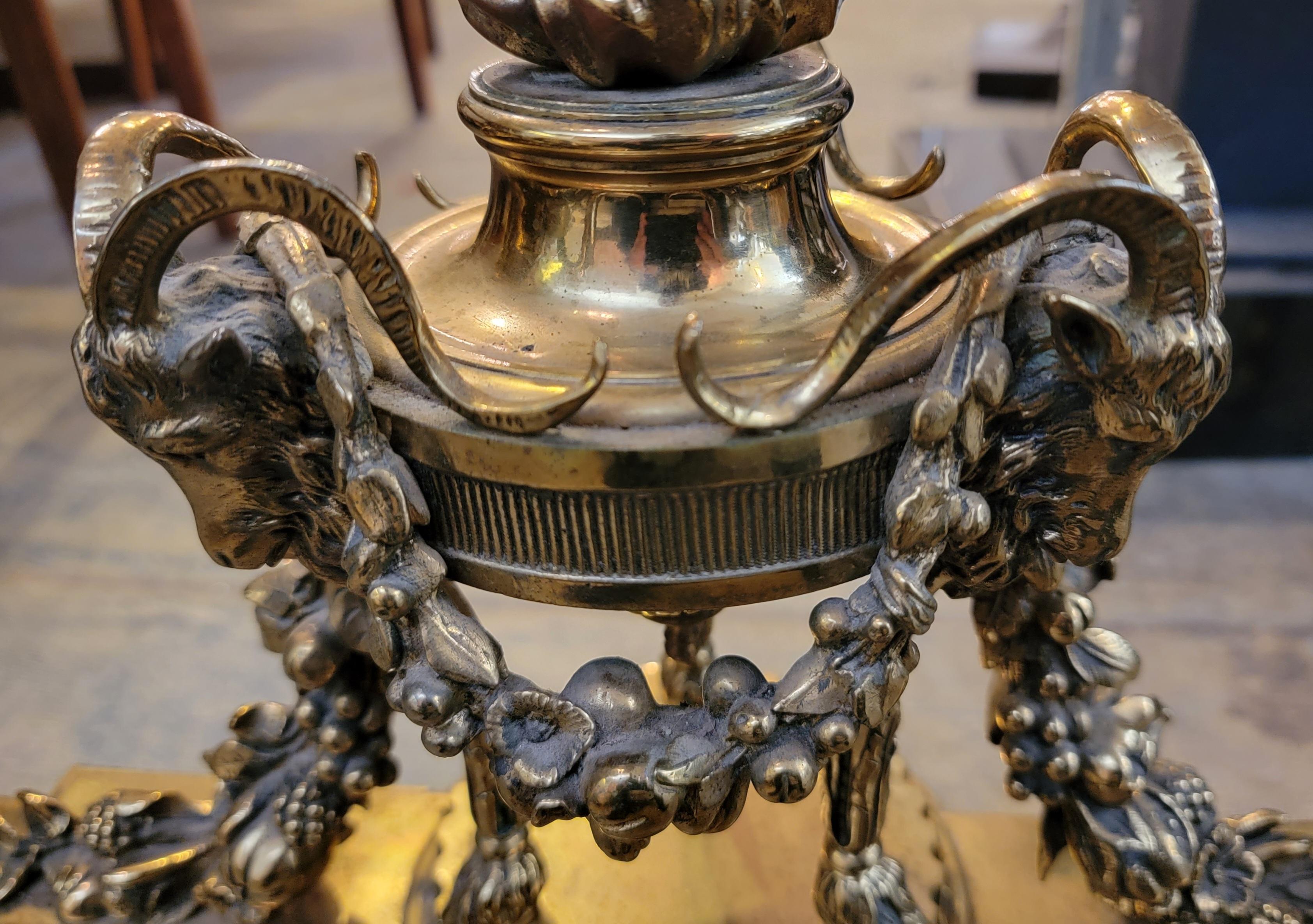 PAIR OF BRASS LOUIS XVI-STYLE CHENETS. Wonderful design with rams on the top portion were the bronze flames tower over the chenets. The ivy flows down to the main area of the bronze chenets to expose a facial figure in the center of teh entire