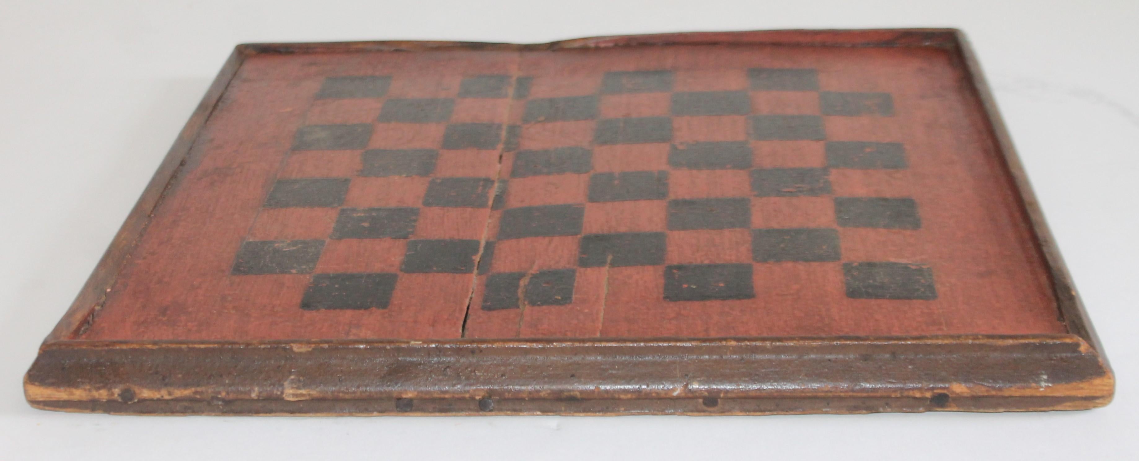 This folky handmade original bitter sweet and black painted surface game board has original picture frame molding and in good condition. This game board has a worn molding trim and wonderful aged patina. Minor age cracks in trim consistent from age