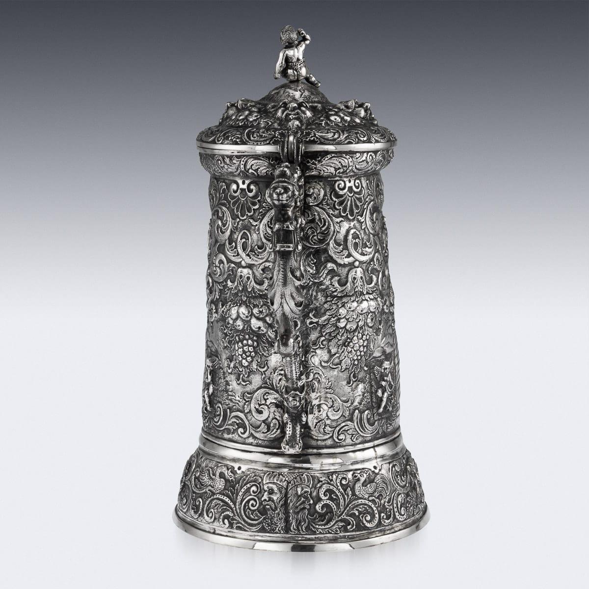 Antique mid-19th century German (Hanau) solid silver impressively large lidded tankard, in the style of the early 16th century pieces, beautifully chased and embossed with bacchanalia and agricultural scenes, embossed with cherubs, grotesque masks