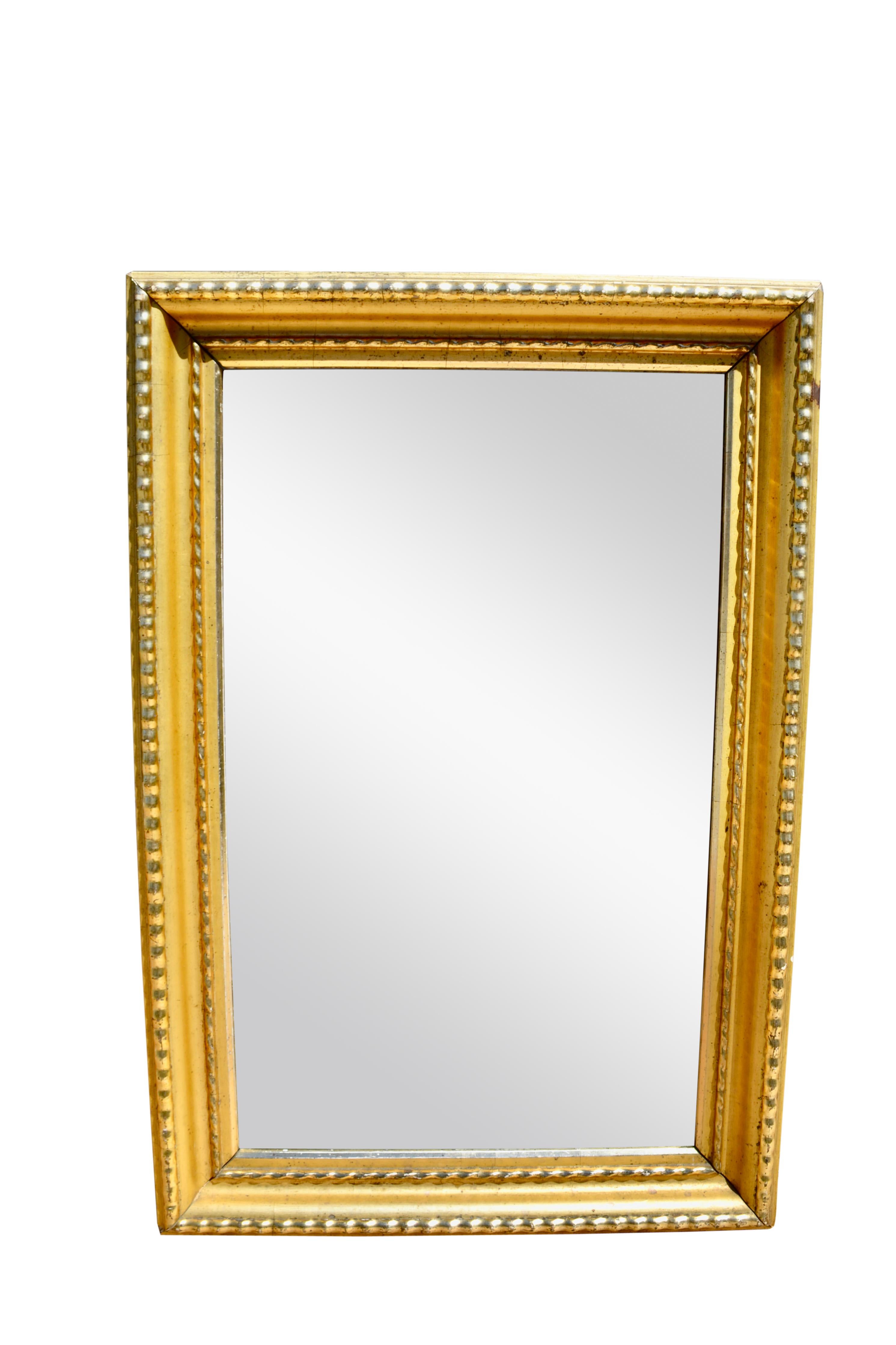 A simple rectangular beveled mirror with a bright beaded water-gilt frame.