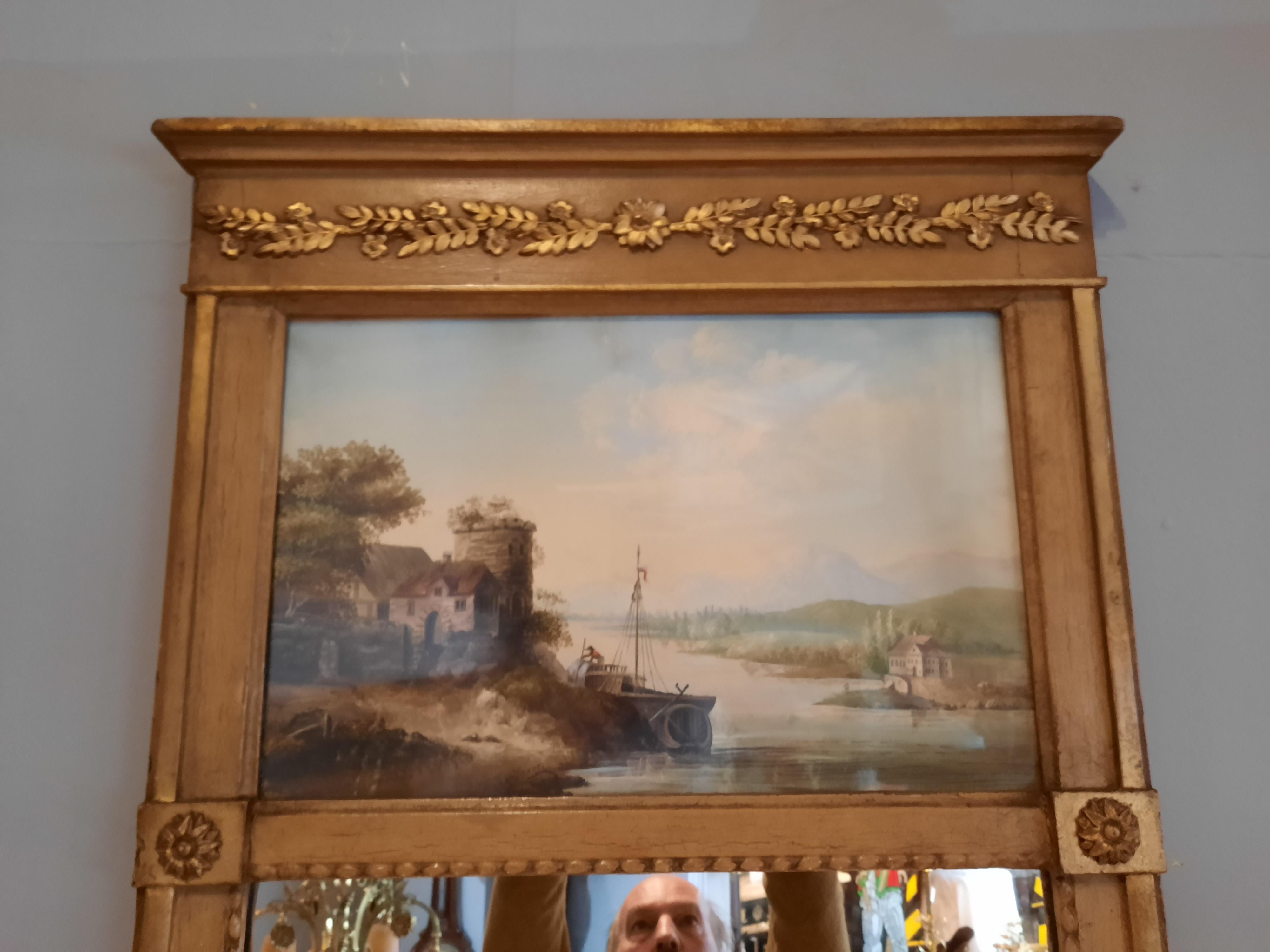 Gilt composite trumeau pier mirror, 19th Century, the frieze with moulded foliate decoration, above painted panel depicting a riverboat set within a landscape with mountains, above rectangular mirror plate, with bead moulded border and applied