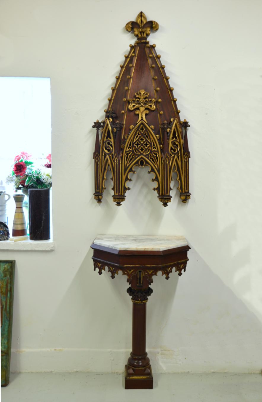 A wonderful Victorian mahogany carved parcel-gilt Gothic Revival Church canopy accompanied by a matching parcel-gilt pier / pedestal table on a turned column with a shaped marble top.
Both pieces are lavished with tracery carvings and parcel gilt