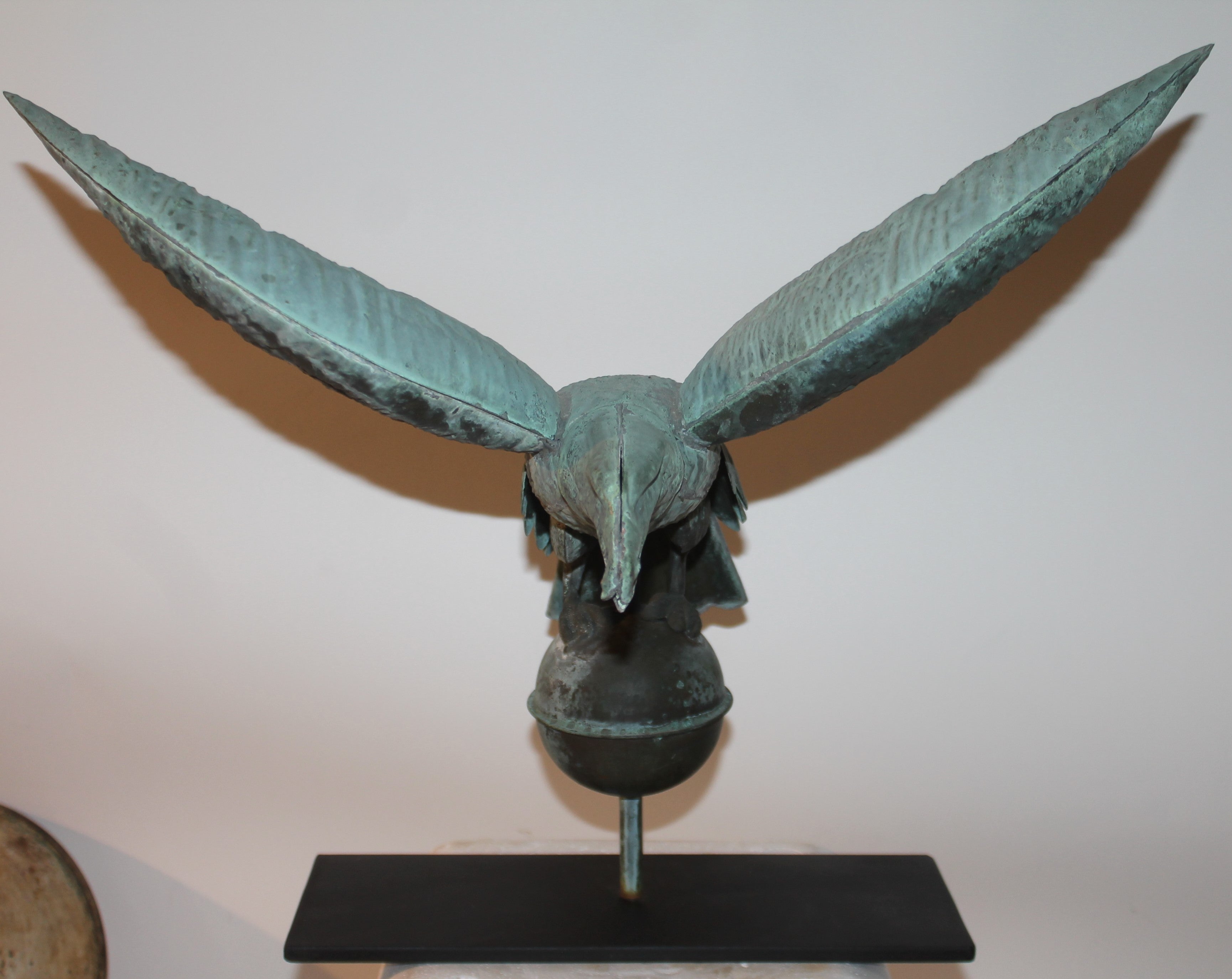 This fine 19th c patinaed eagle weather vane was found in New England. The iron base is a custom made stand. The condition is very good on this early fine with no dents or holes. Wonderful undisturbed surface.