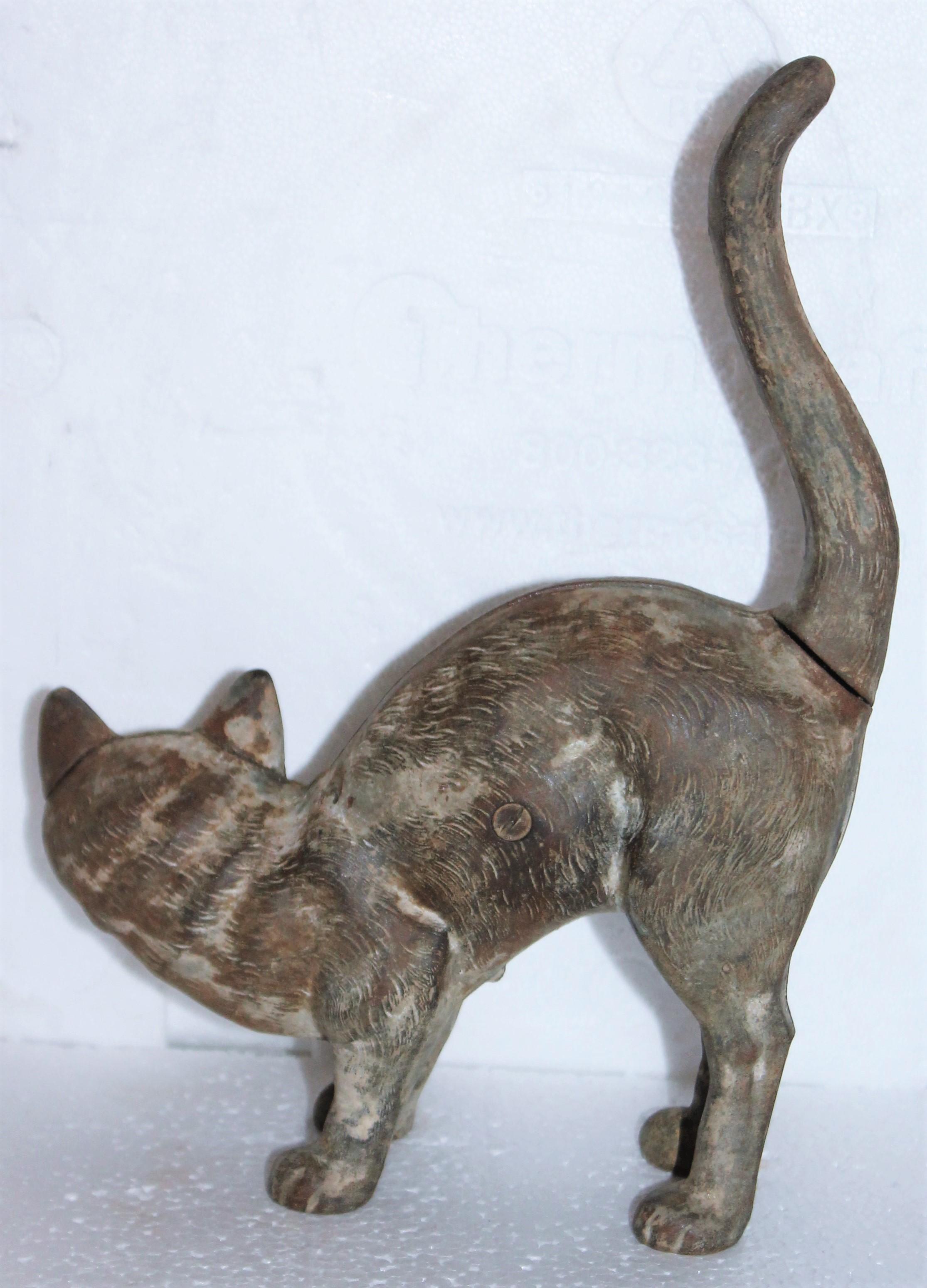 This folky cast iron cat door stop has a nice aged patinated surface. The condition is very good and it is a heavy doorstop.