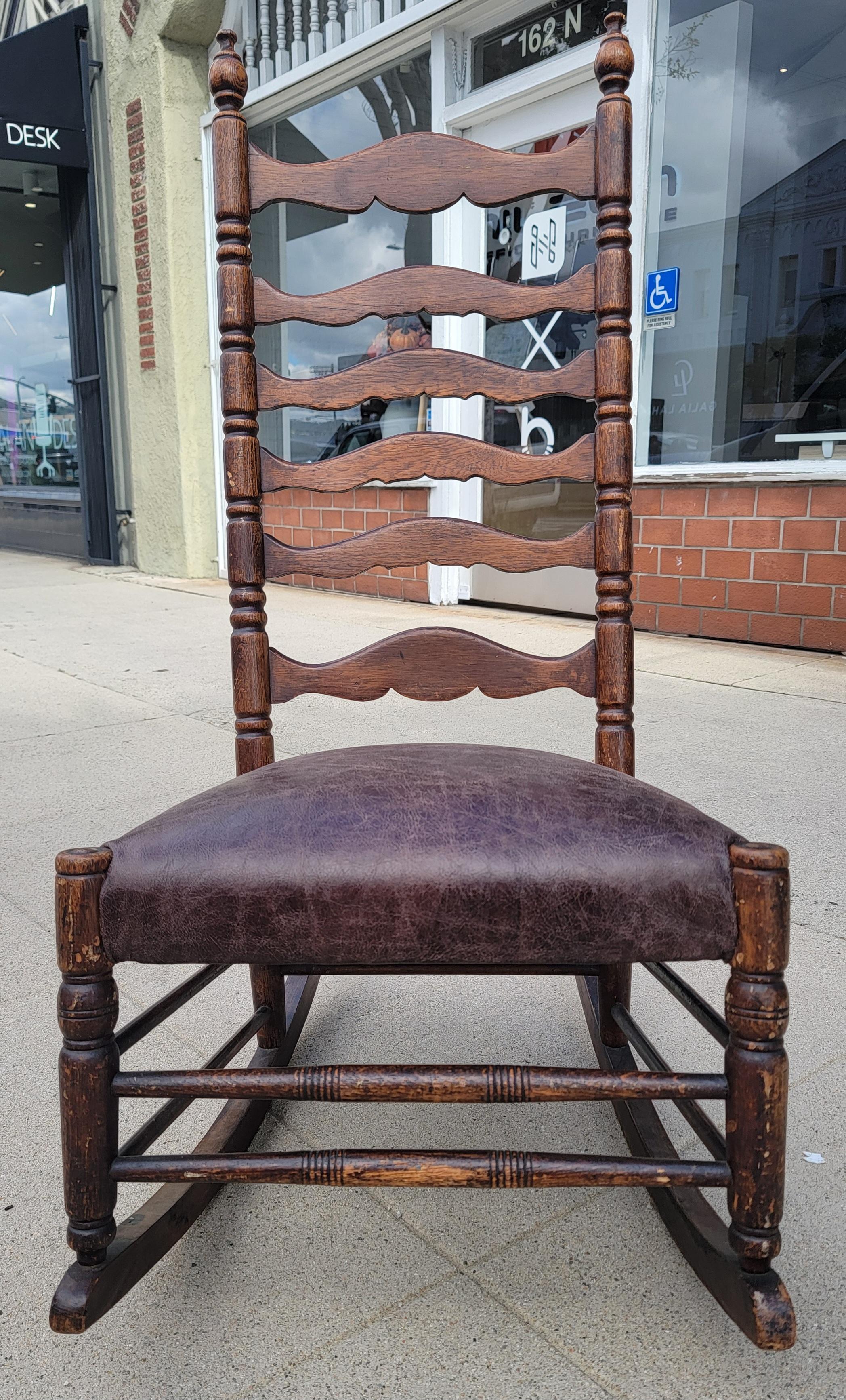 19Thc Early New England tall ladder back rocking chair with leather seat.This amazing rocking chair has a fine aged patina. and is very comfortable.The condition is very good.