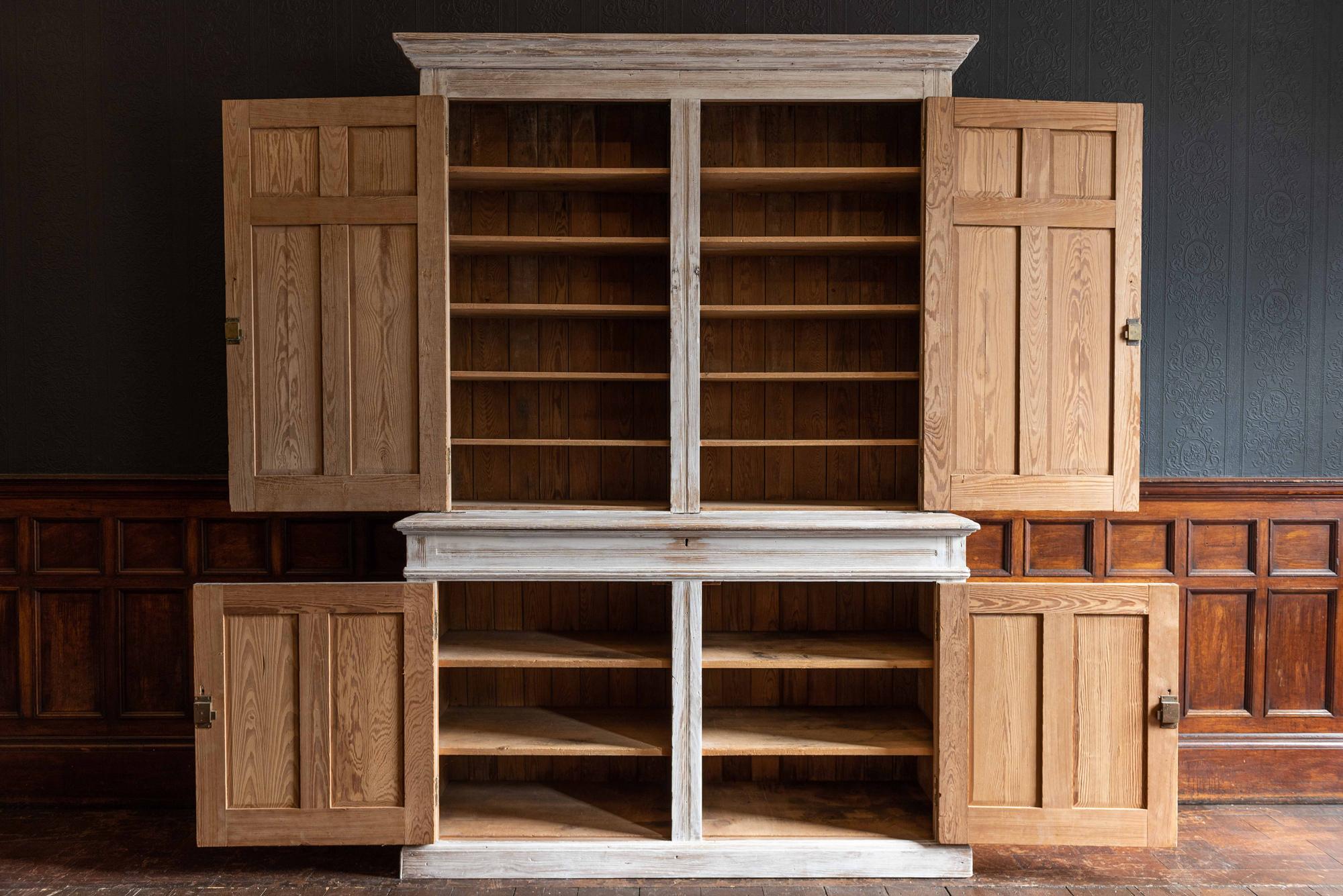 19th century large English white limewash housekeepers cupboard,
circa 1890.

Large scale limewash pitch pine housekeepers cupboard with contrasting ebonized mahogany knobs.
Paneled doors with shelves to the top and base and a secret lift up